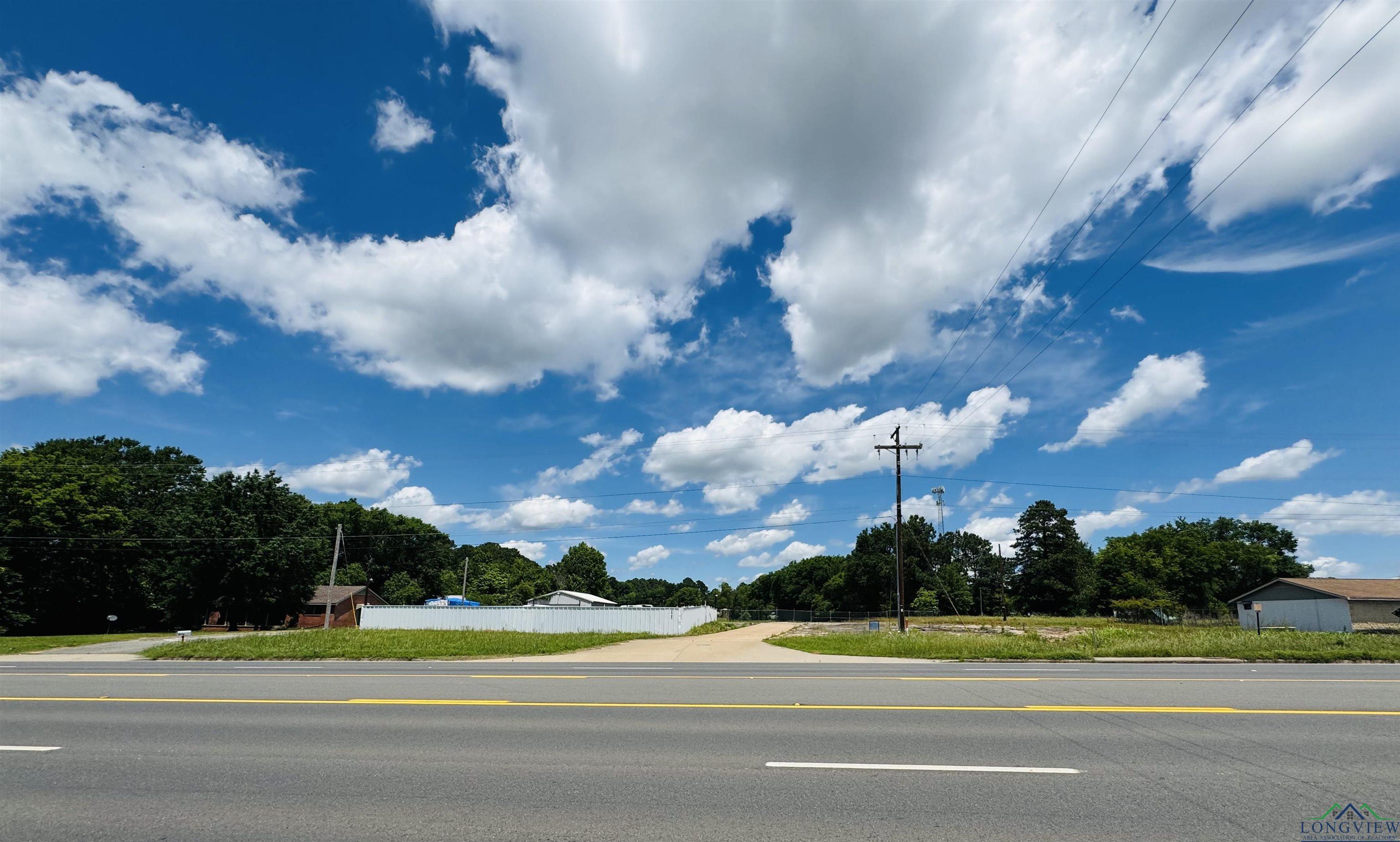 Image 0: View of asphalt road with view of wooded area, Community