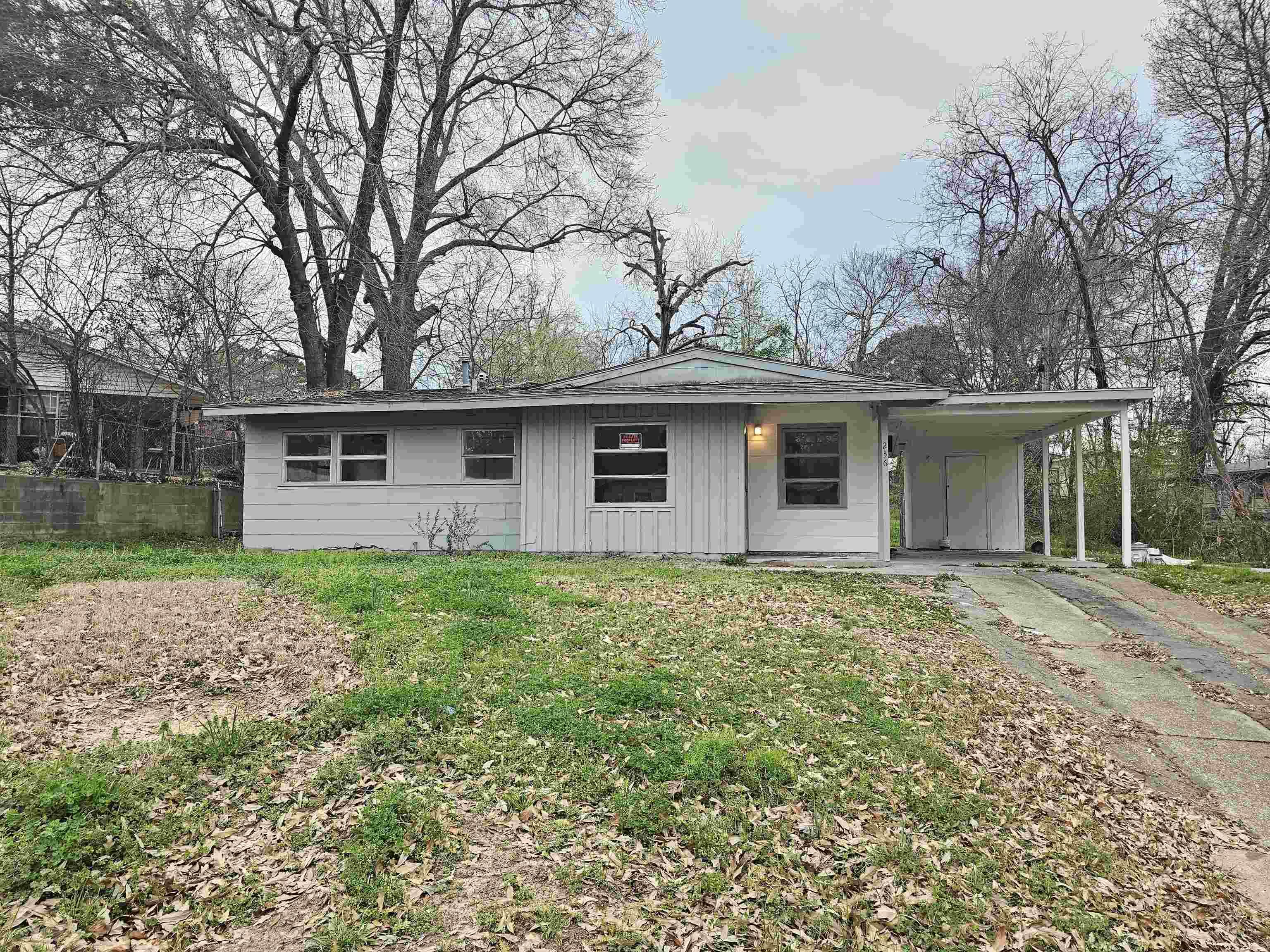 Image 0: View of front of house with an attached carport, a front lawn, board and batten siding, driveway, and a porch, Front Of Structure