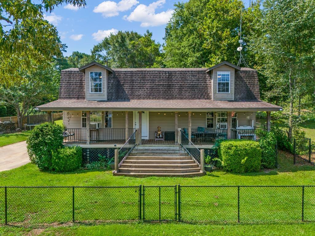 Image 2: View of front of house featuring a gate, a shingled roof, a fenced front yard, and covered porch, Front Of Structure