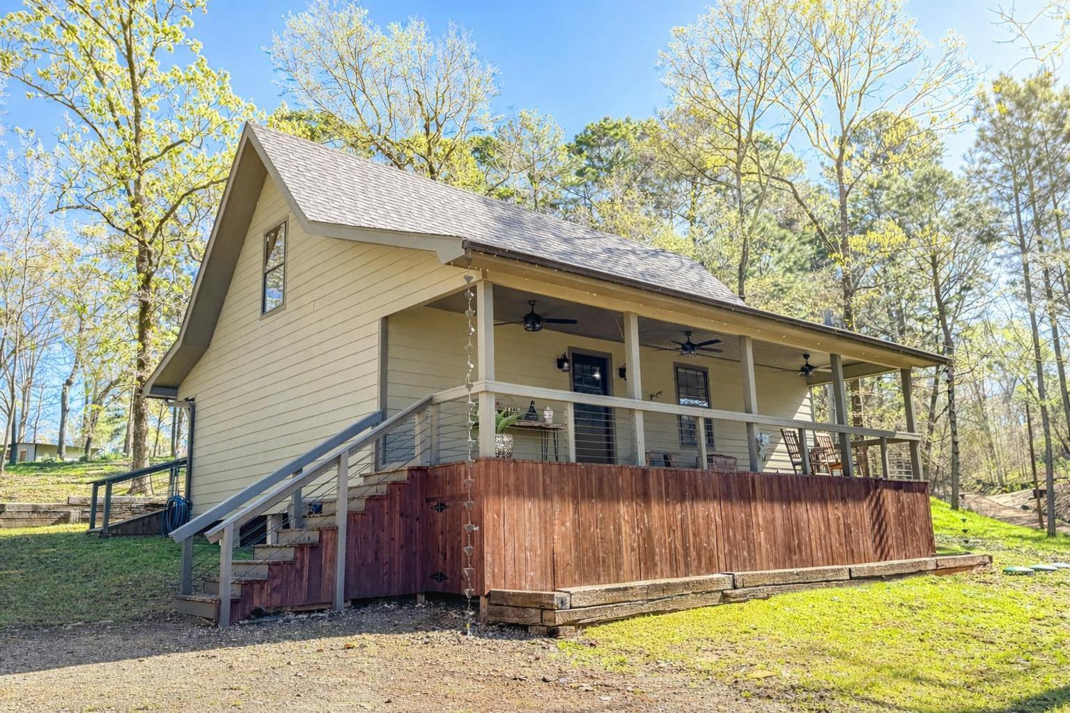 Image 2: View of side of home with ceiling fan, a shingled roof, a porch, and a lawn, Side Of Structure