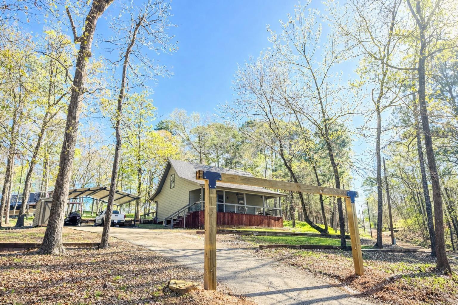 Image 3: View of front of house featuring a detached carport, driveway, and a porch, Front Of Structure
