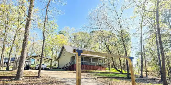 Image 3: View of front of house featuring a detached carport, driveway, and a porch, Front Of Structure