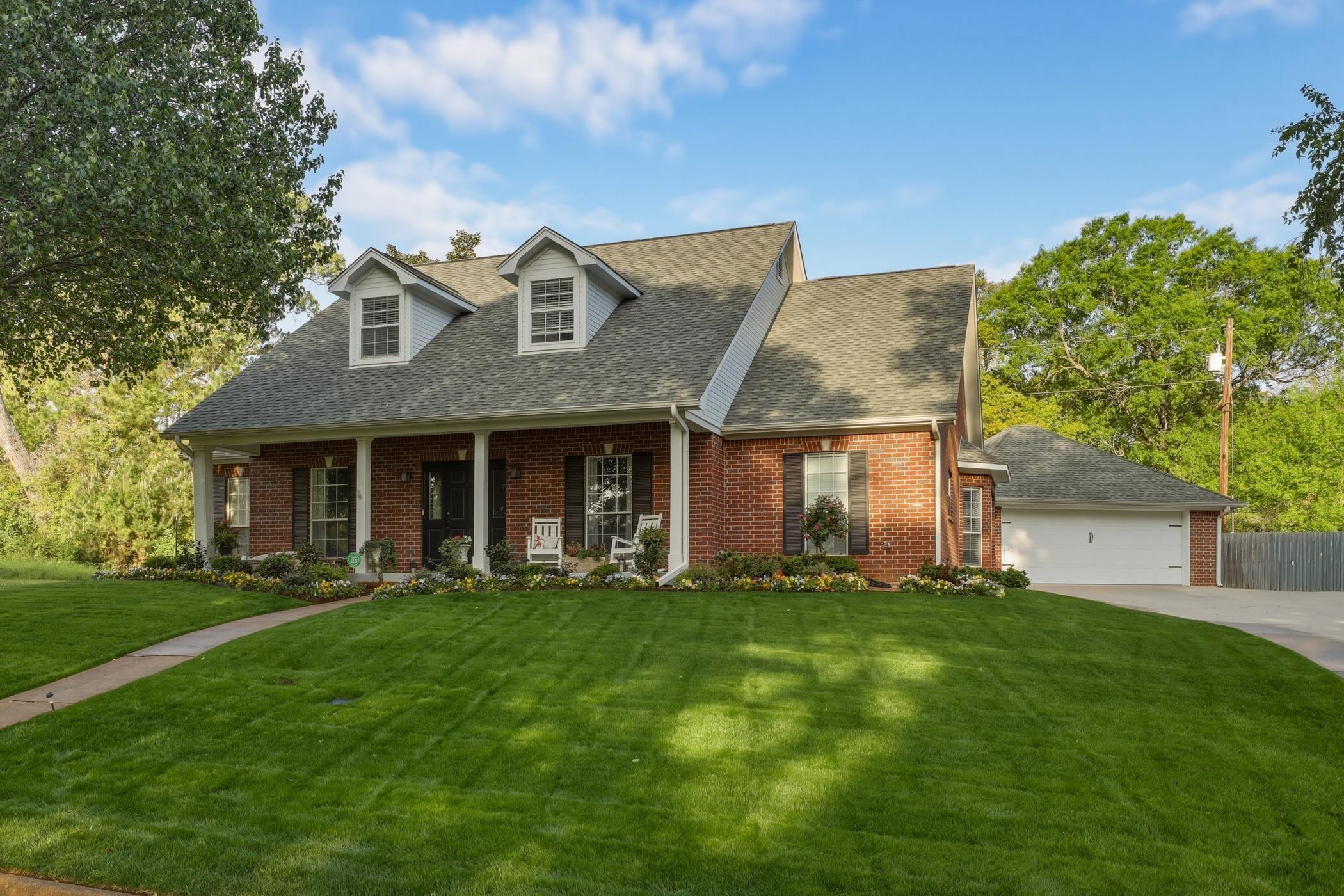 Image 1: Cape cod house featuring brick siding, a front lawn, a shingled roof, and covered porch, Front Of Structure