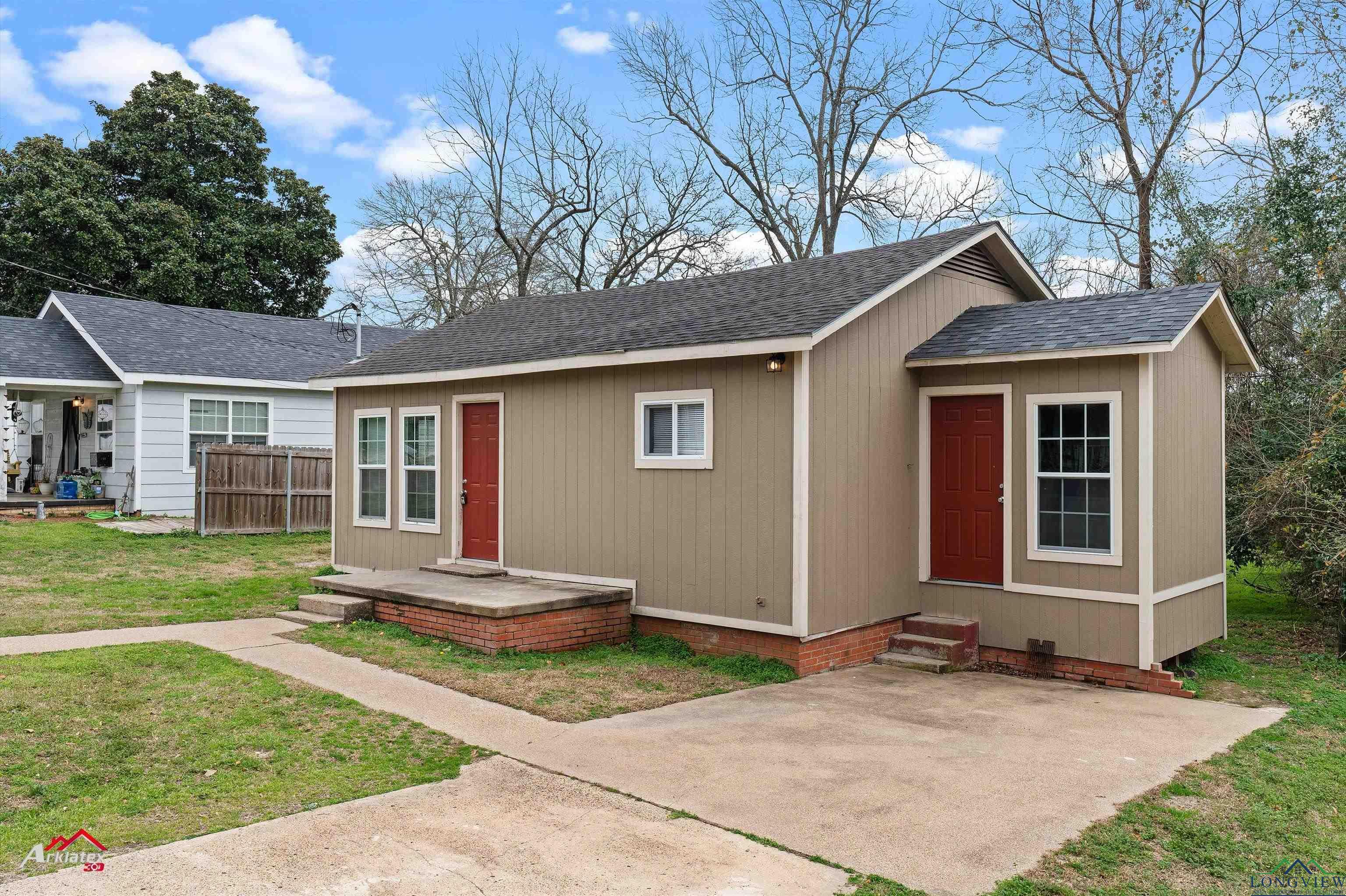 Image 1: View of front of property featuring a patio area and a front lawn, Front Of Structure
