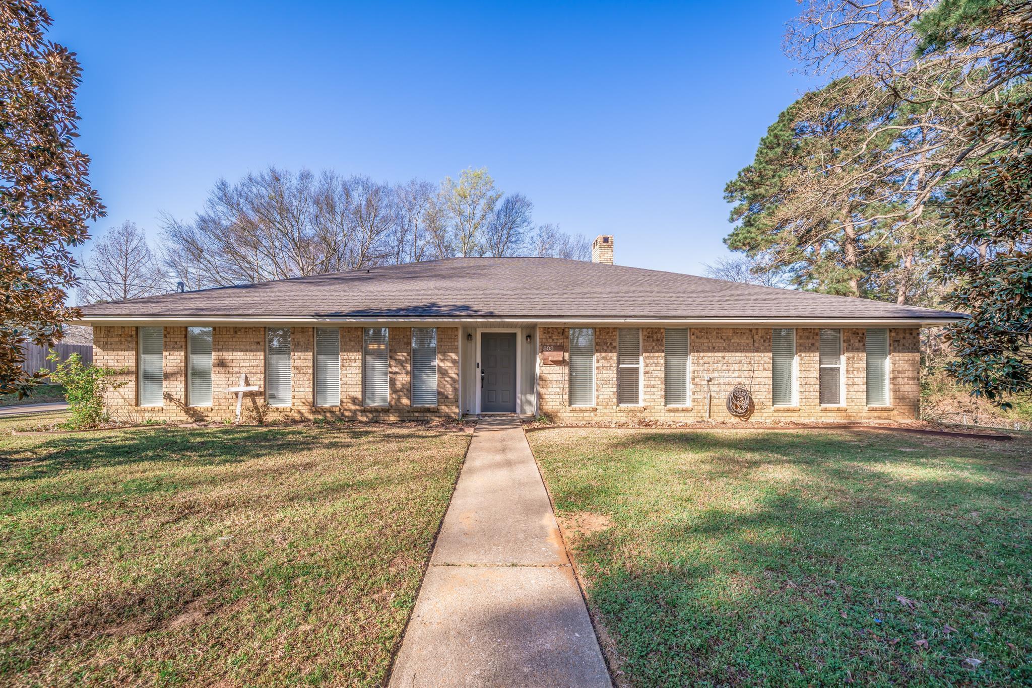 Image 0: Ranch-style home featuring a front lawn, a chimney, brick siding, roof with shingles, and a porch, Front Of Structure