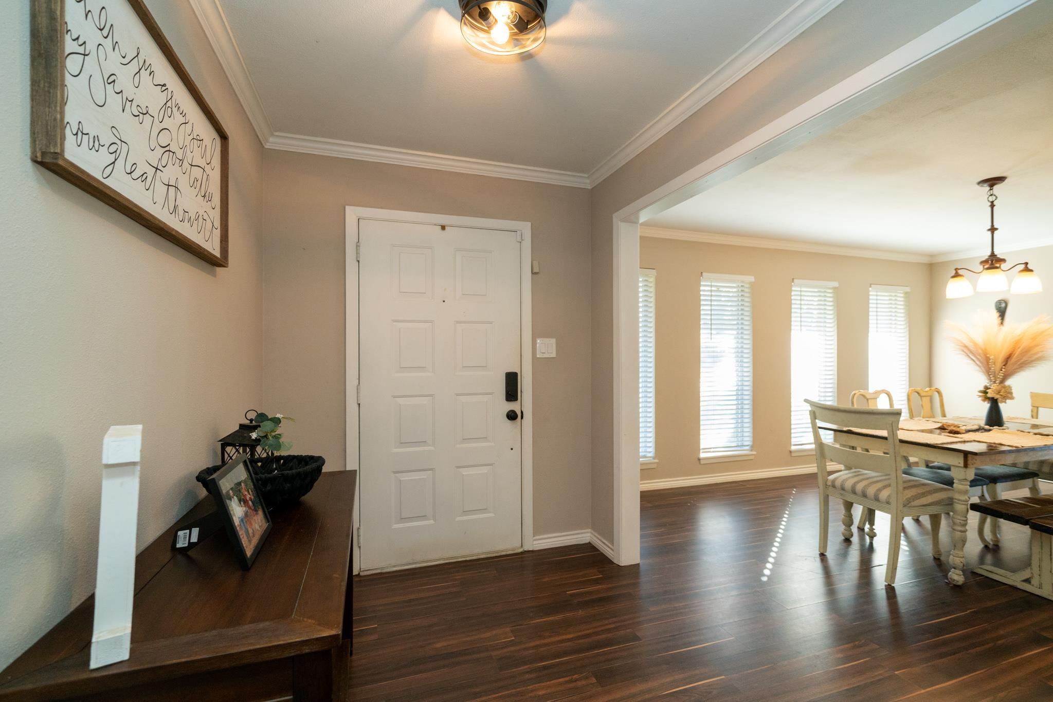 Image 1: Entrance foyer with ornamental molding, dark wood-type flooring, and hanging lights, Entrance Foyer