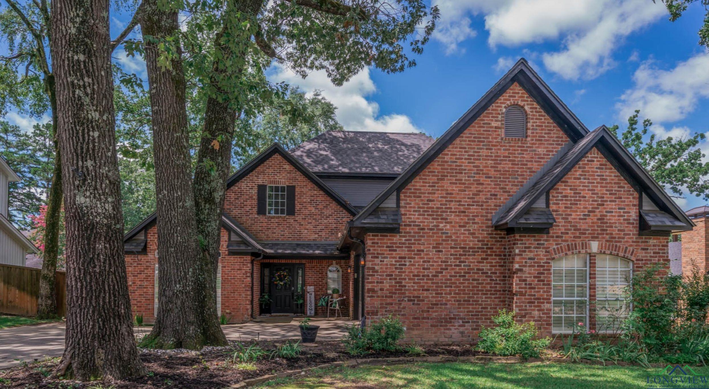 Image 1: View of front facade with brick siding and a shingled roof, Front Of Structure