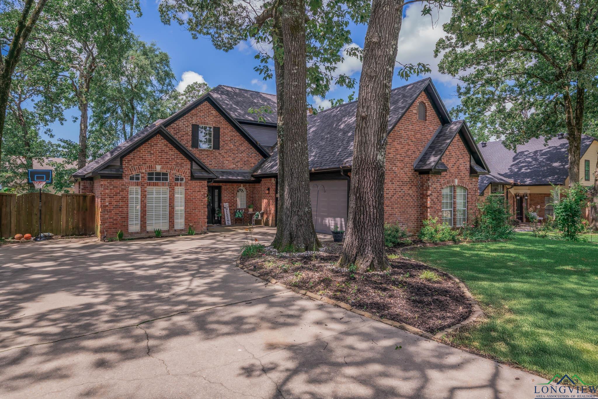 Image 3: View of front facade featuring driveway, brick siding, and an attached garage, Front Of Structure