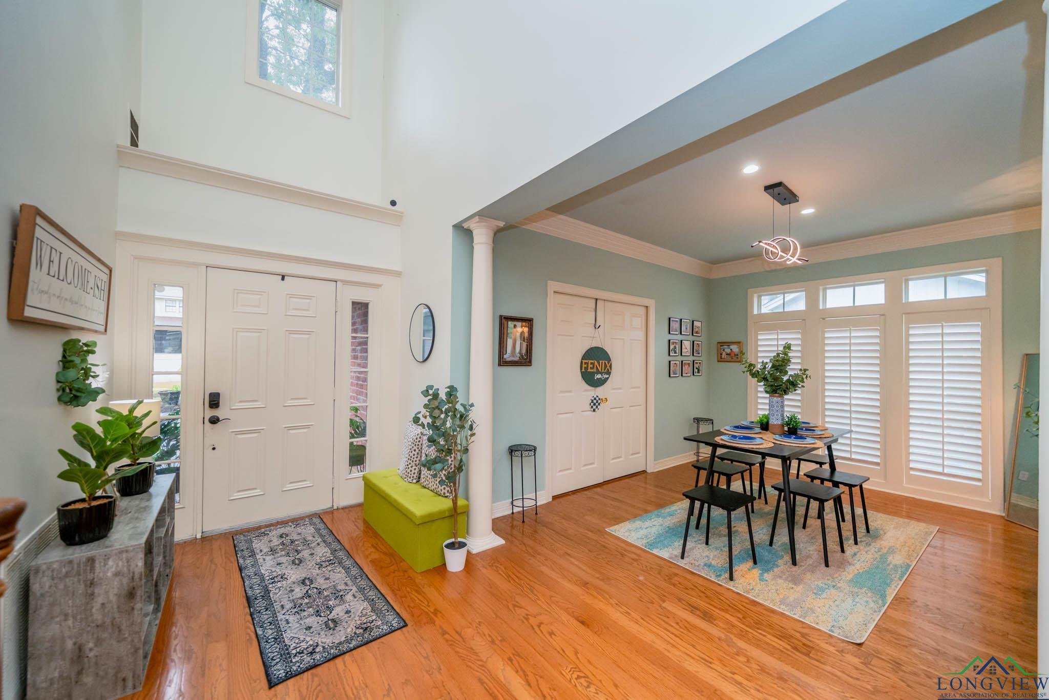 Image 4: Entrance foyer with decorative columns, wood finished floors, healthy amount of natural light, ornamental molding, and a high ceiling, Entrance Foyer