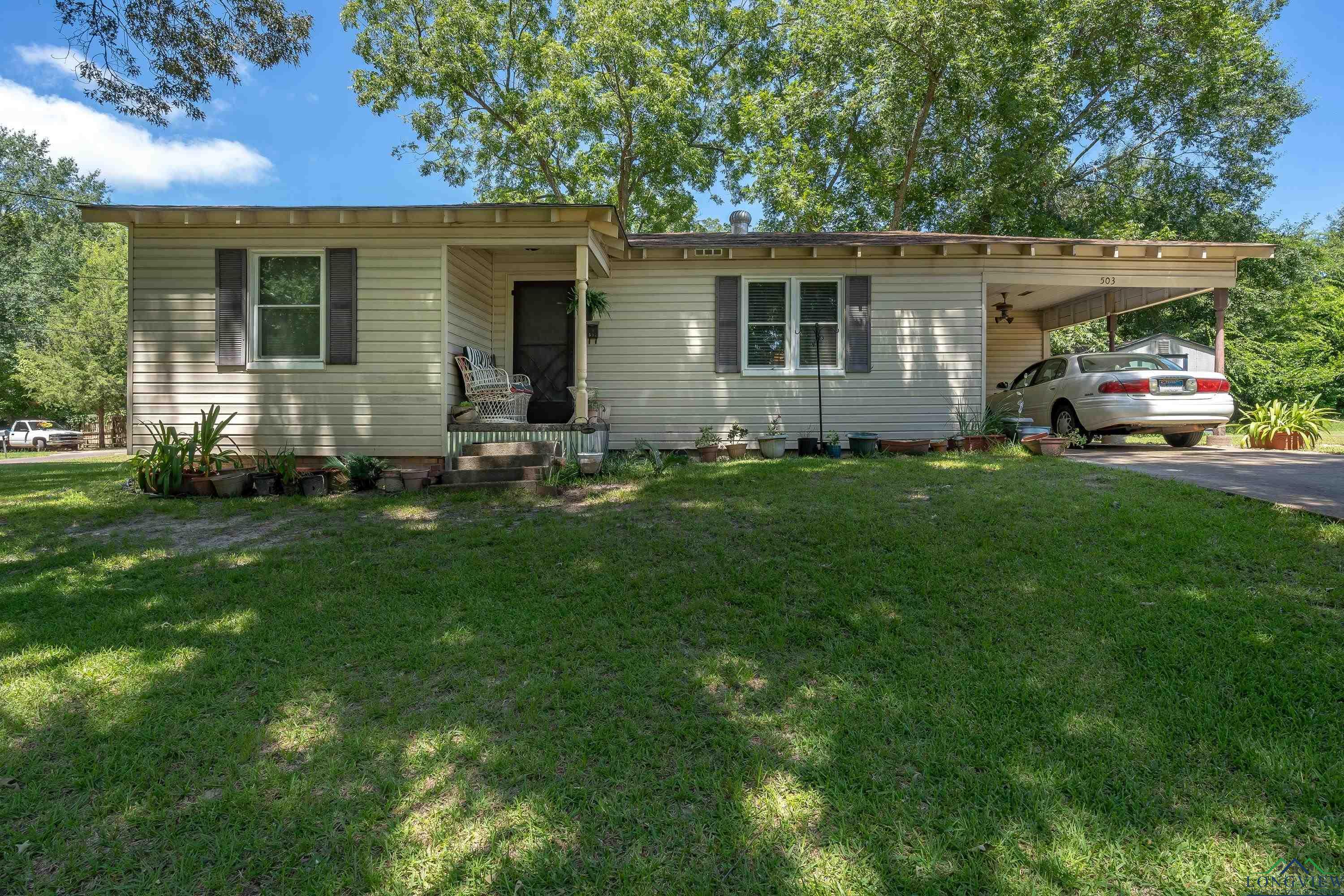 Image 1: View of front of house featuring an attached carport, a front lawn, and concrete driveway, Front Of Structure
