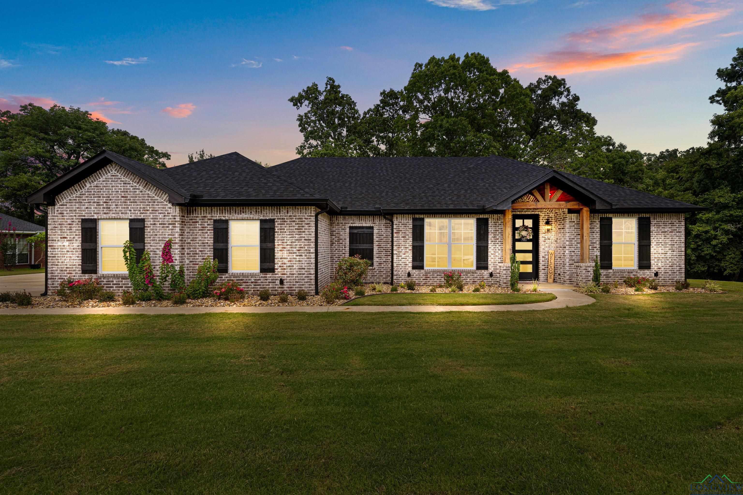 Image 3: View of front of house with brick siding, a yard, and a shingled roof, Front Of Structure