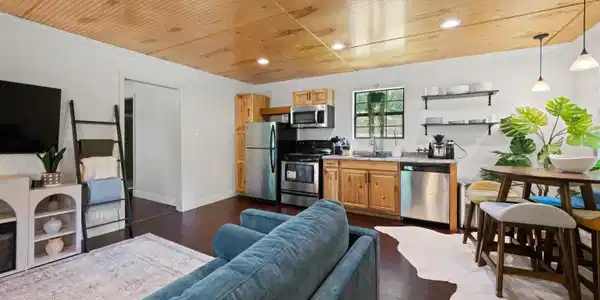 Image 2: Open-concept living area featuring rich wood-finish flooring and a wood-paneled ceiling, Living Room