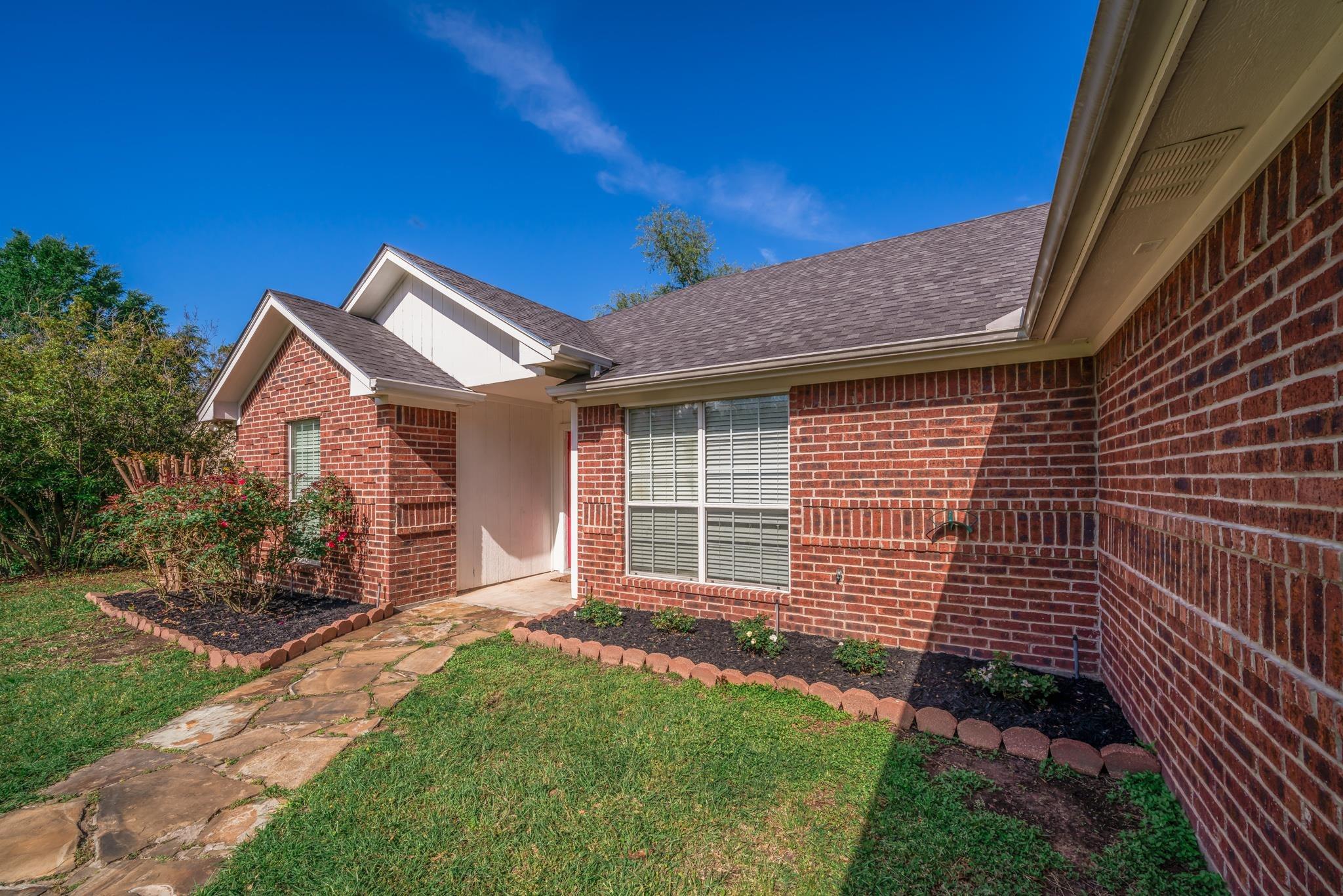 Image 1: Brick exterior with white trim and a gabled roofline, Entry