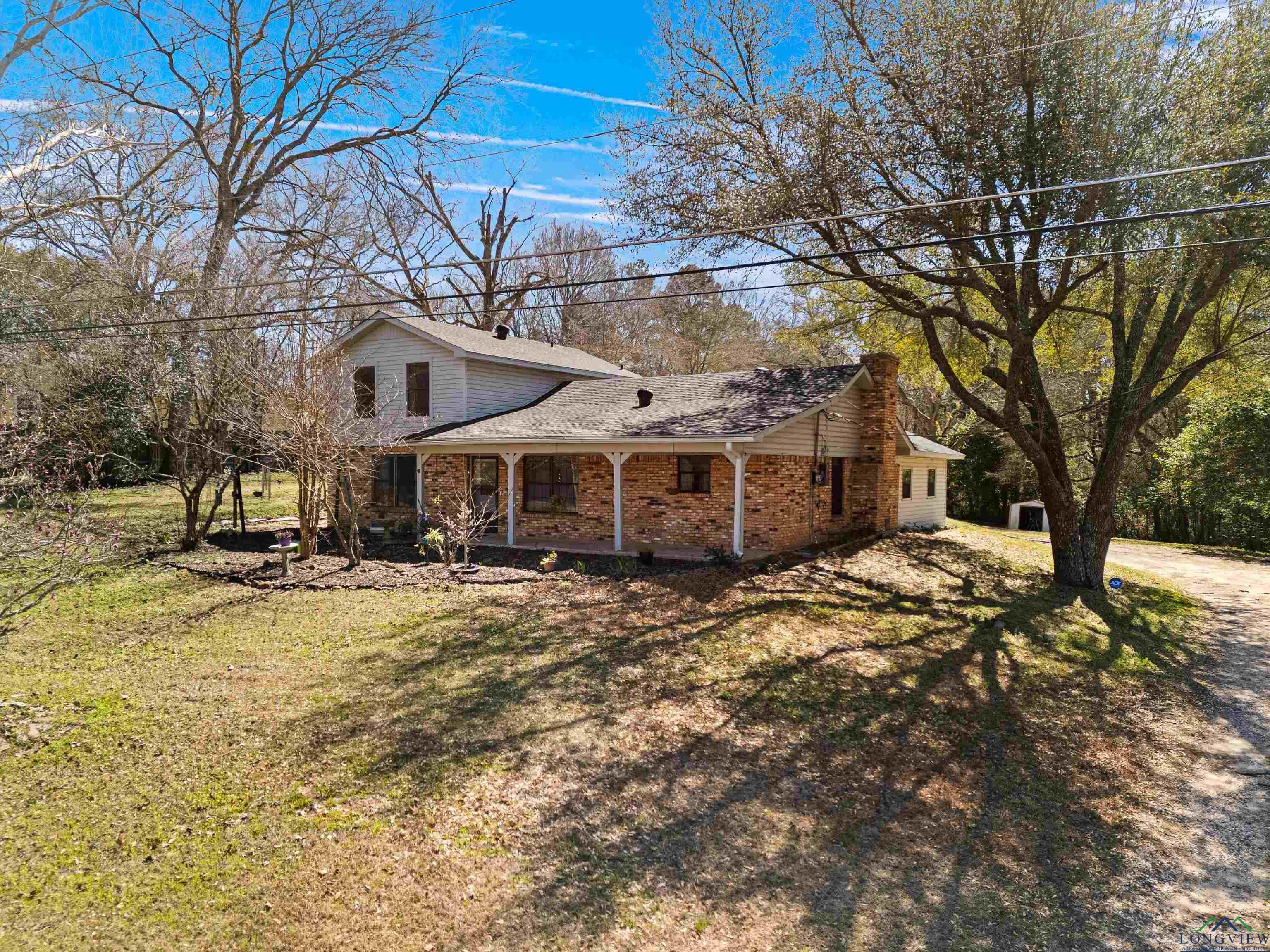 Image 1: View of side of home with a yard, covered porch, and brick siding, Front of Structure