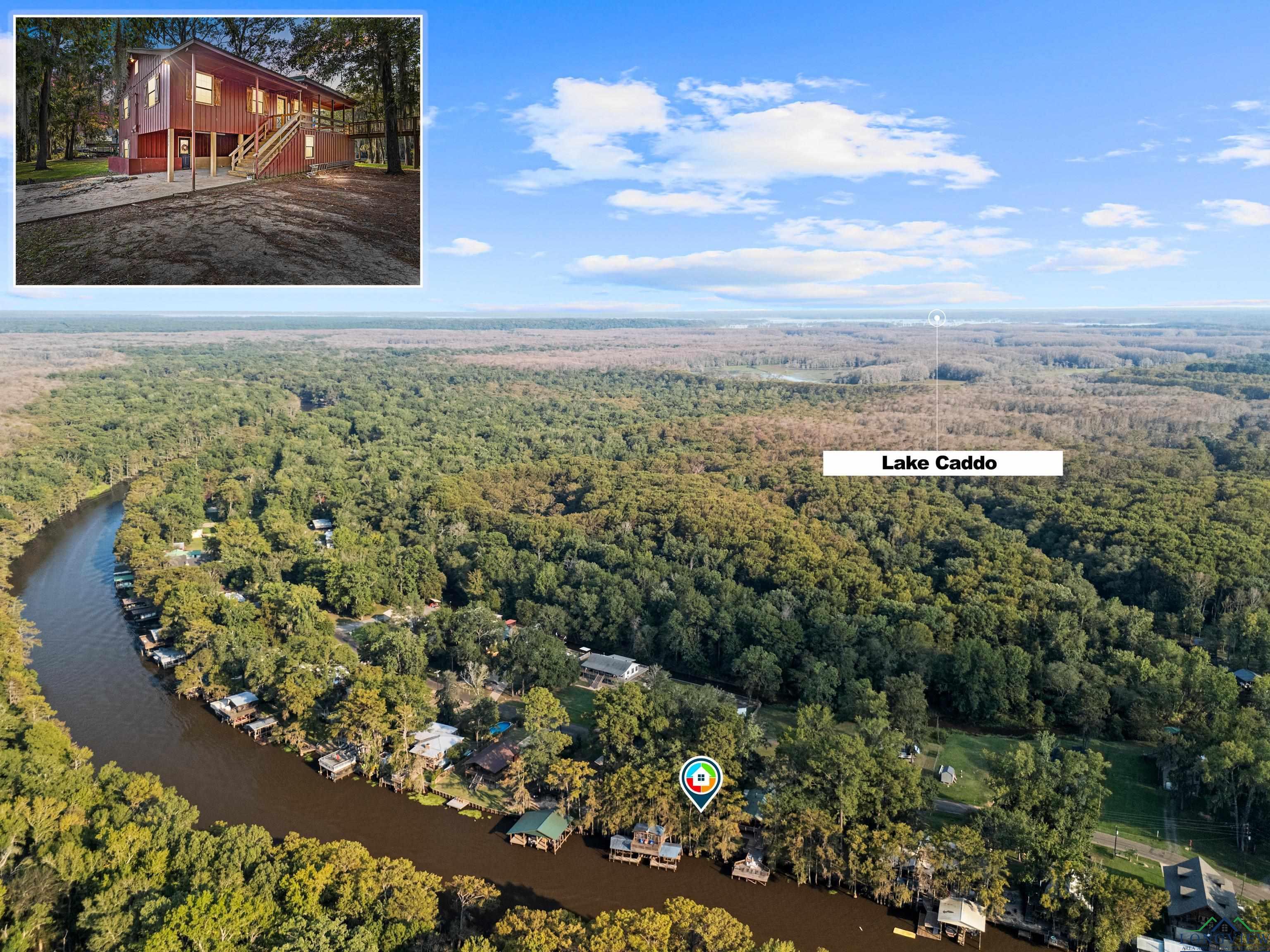 Image 1: View of property location with a heavily wooded area and a nearby body of water, Aerial View