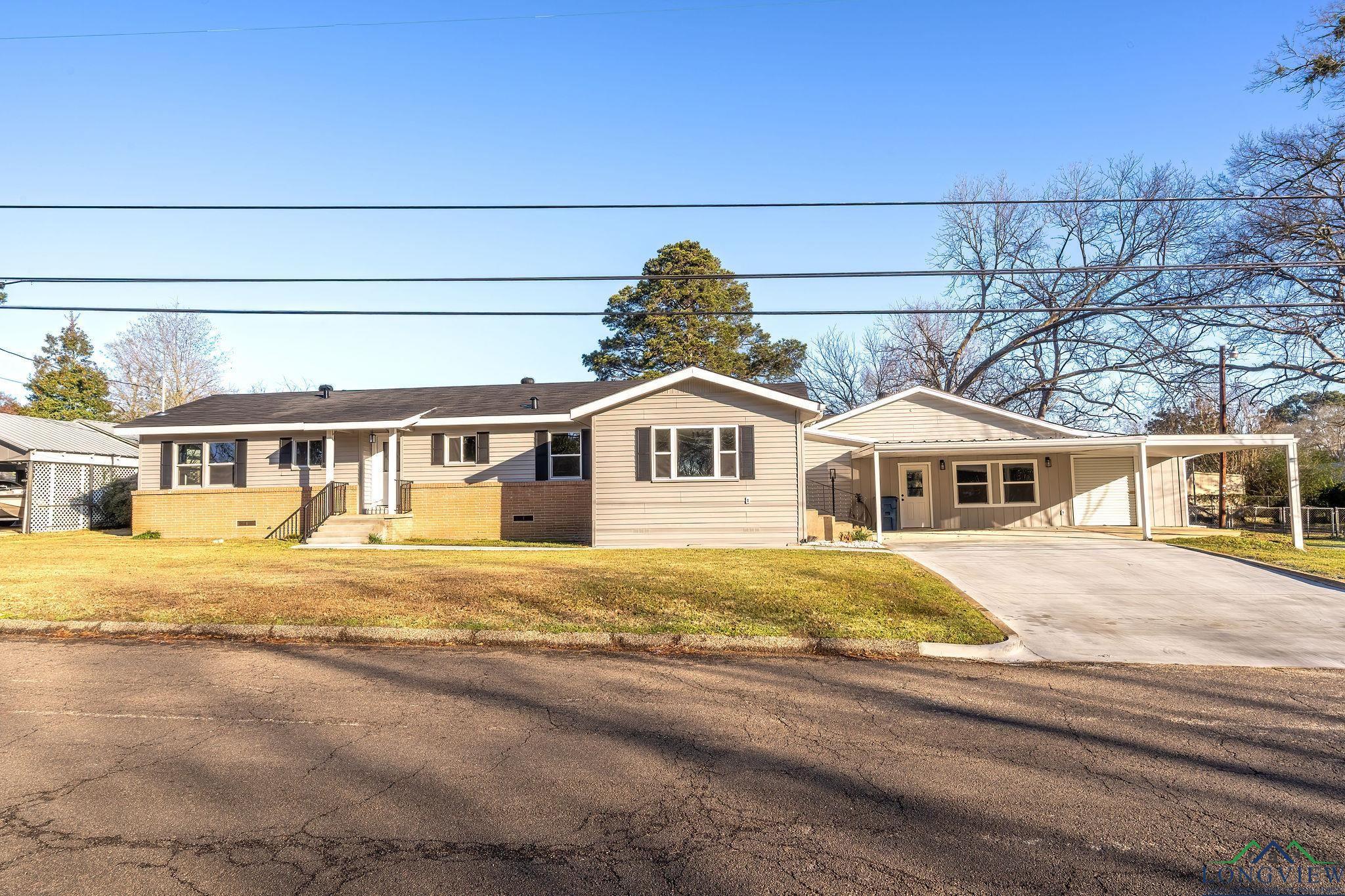 Image 0: Ranch-style house with a carport, concrete driveway, and a front lawn, Front Of Structure
