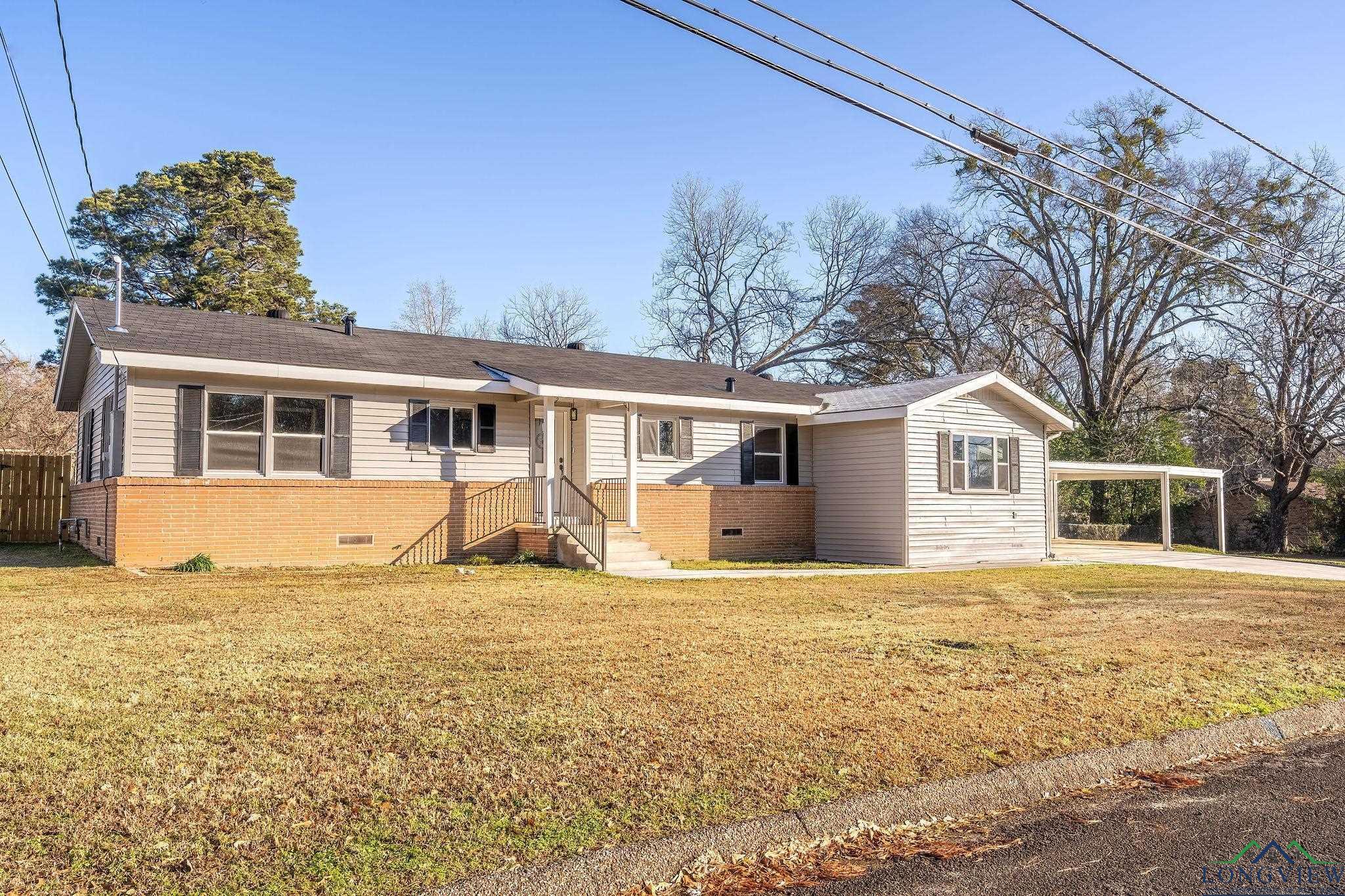 Image 2: View of front of home with brick siding, a front lawn, fence, and crawl space, Front Of Structure