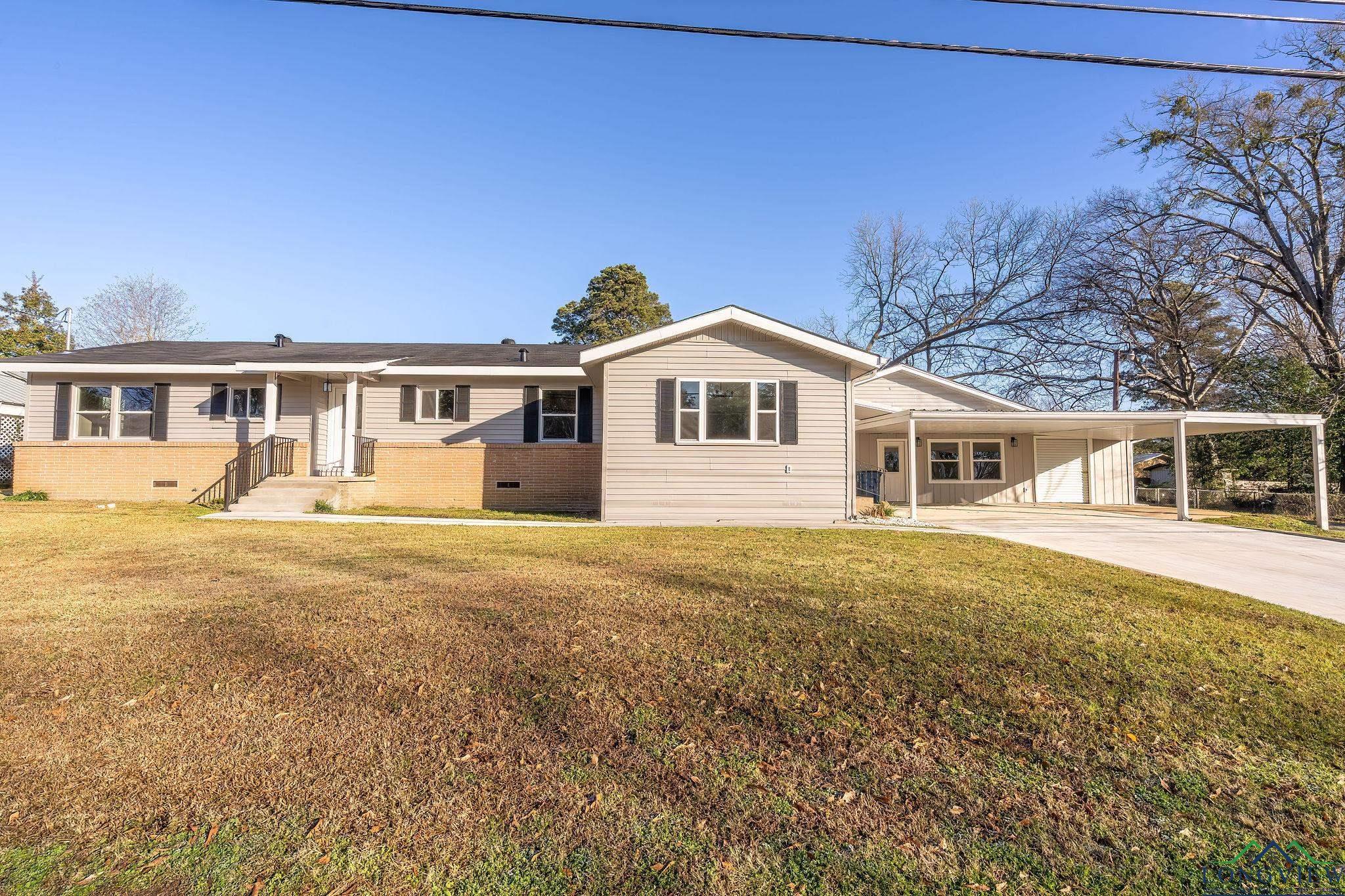 Image 3: View of front of property with crawl space, a carport, and a front lawn, Front Of Structure