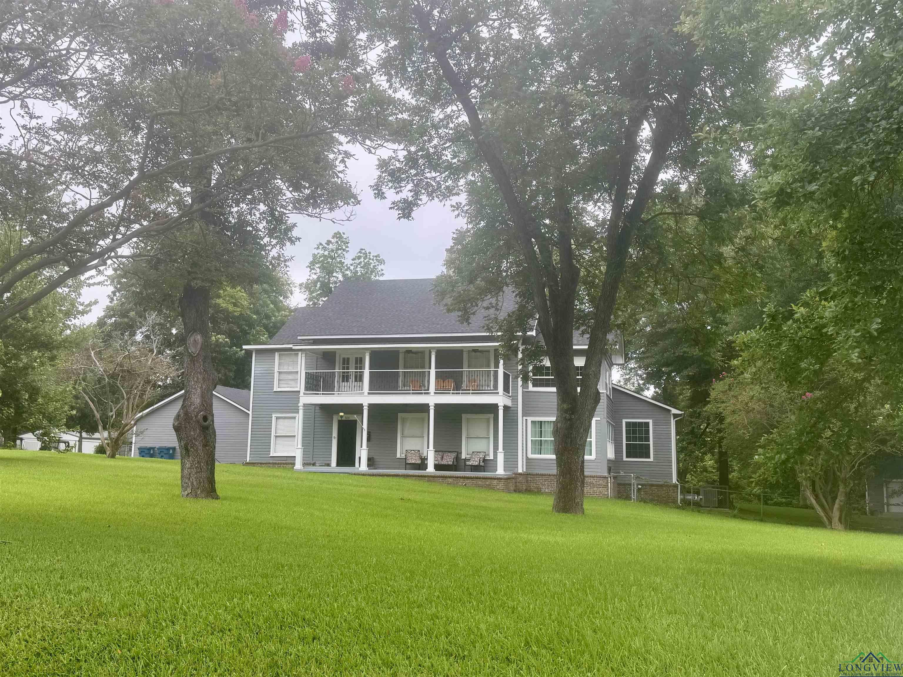 Image 1: View of front facade with a front lawn and a balcony, Front Of Structure