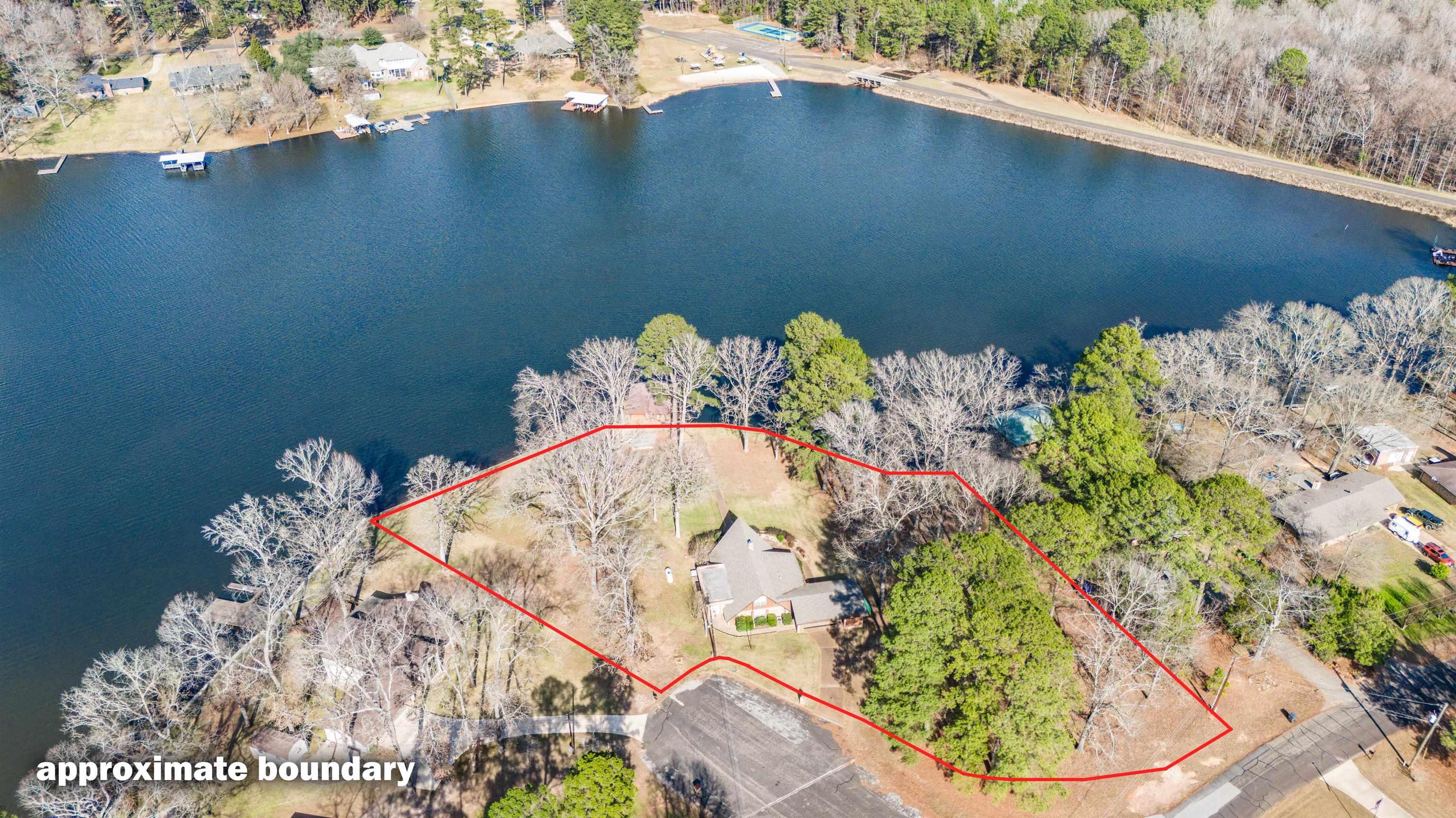 Image 2: Aerial overview of property's location featuring a nearby body of water and property parcel outlined, Aerial View