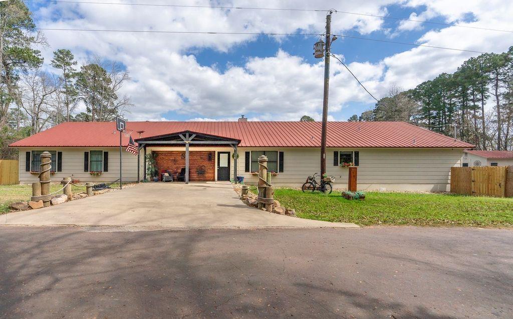 Image 0: Ranch-style home with a metal roof, driveway, and a patio, Front Of Structure
