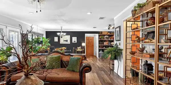 Image 2: Living room with dark wood-type flooring, ornamental molding, a ceiling fan, and suspended lighting, Main Living Room