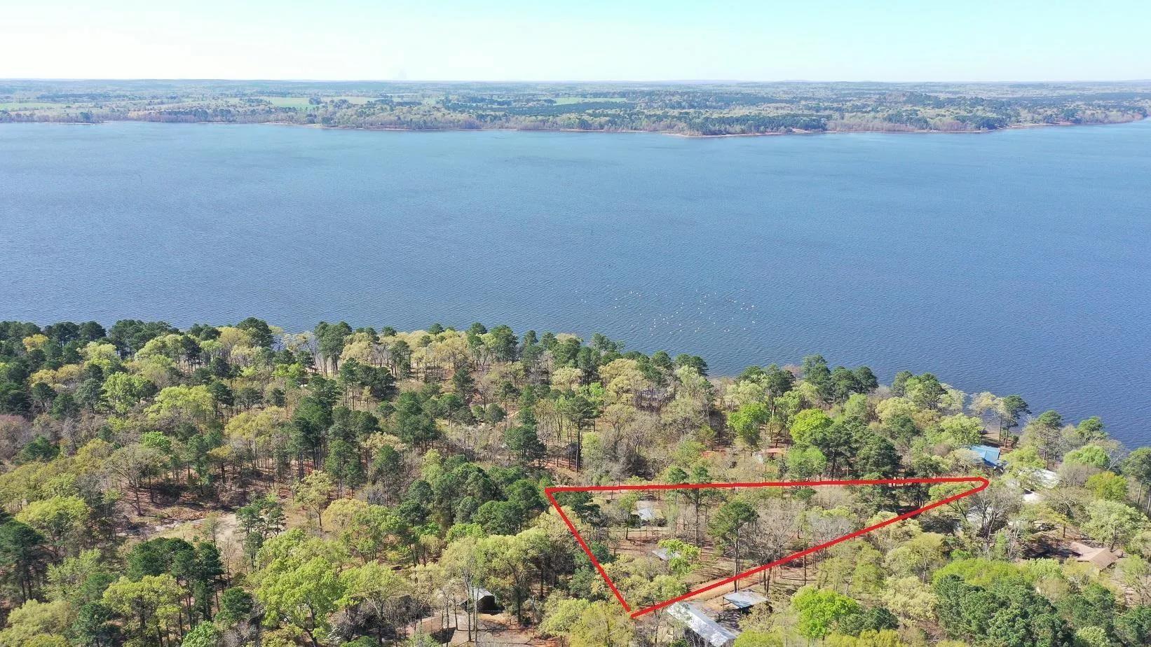 Image 1: Aerial overview of property's location featuring property parcel outlined and a large body of water, Aerial View