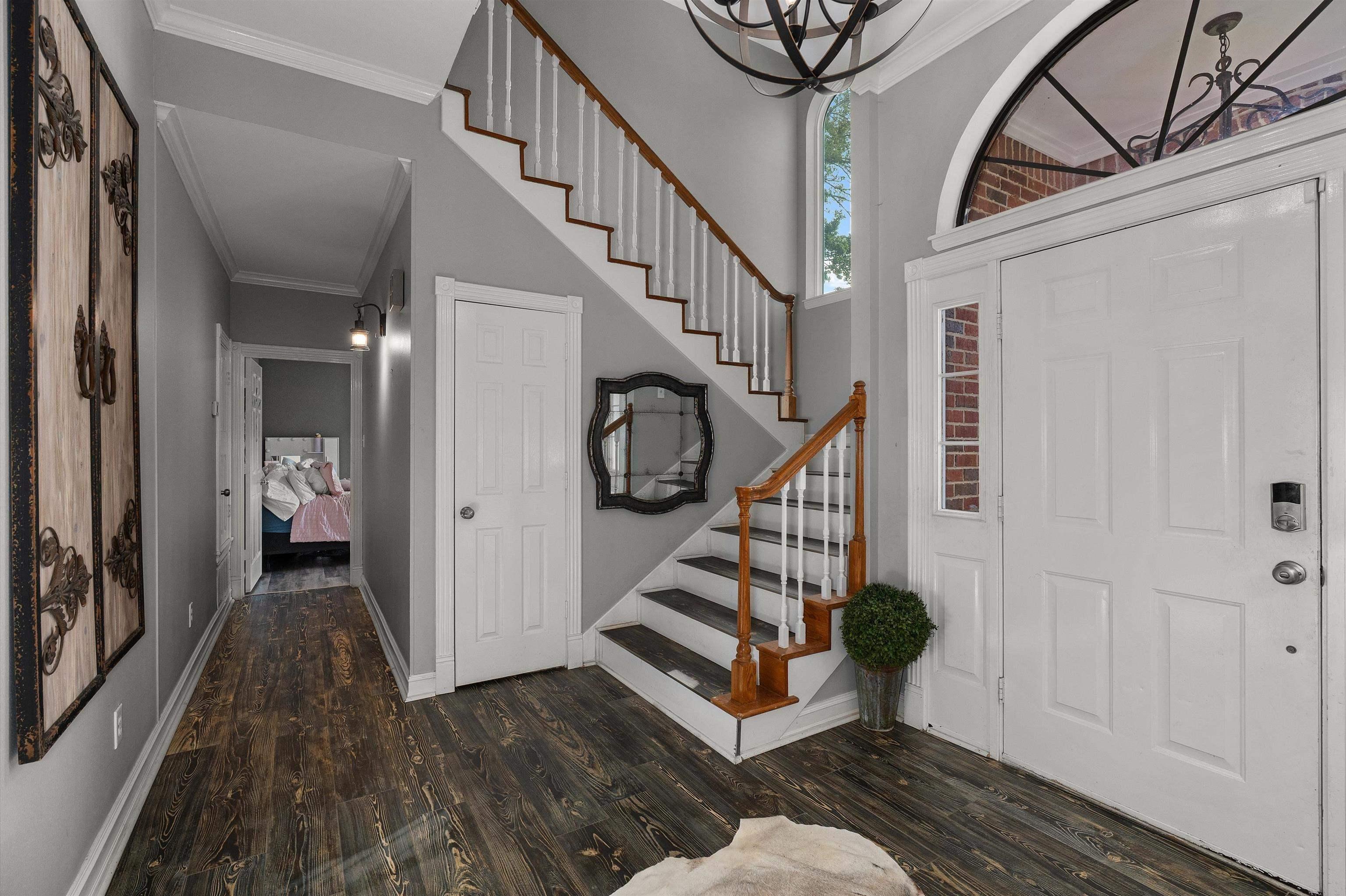 Image 2: Two-story foyer featuring dark wood-finish flooring and a staircase with white risers and wood treads, Entrance Foyer