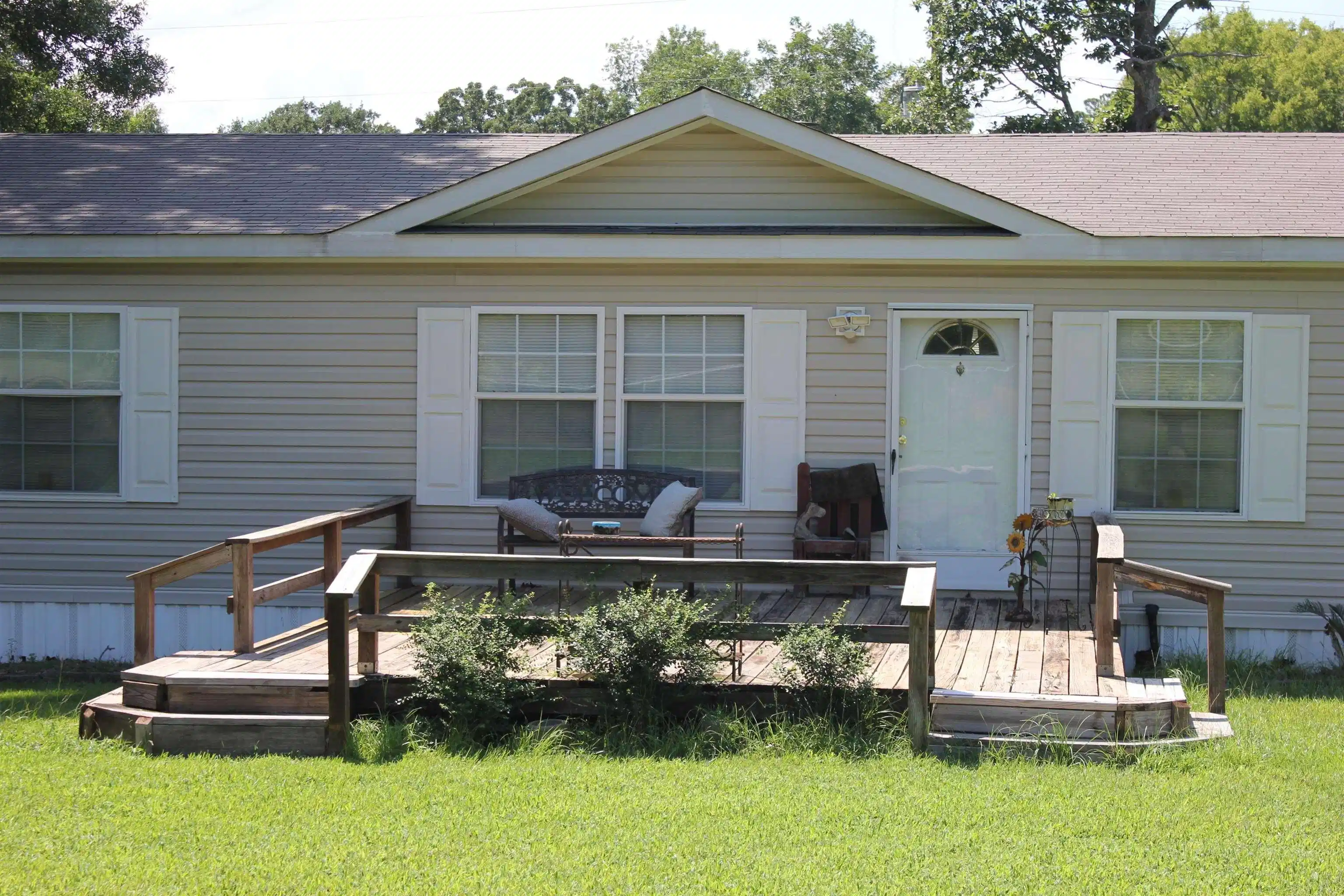 Image 0: Front exterior featuring light-colored horizontal siding, a gabled entry, and a covered porch, Front Of Structure