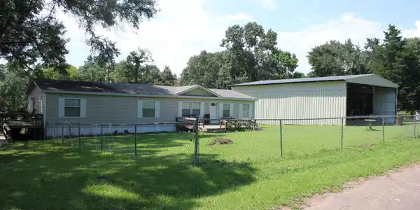 Image 1: Single-story residence featuring light-colored siding and a covered front entry, Front Of Structure