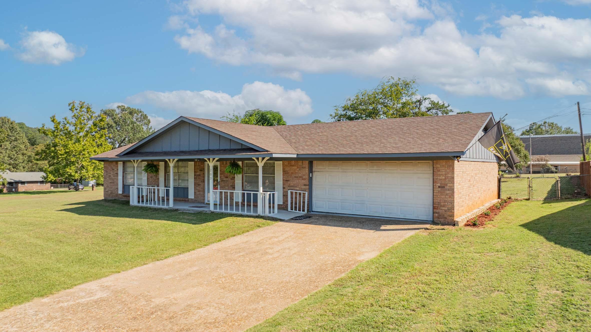 Image 0: Ranch-style home featuring a porch, brick siding, roof with shingles, and driveway, Front Of Structure