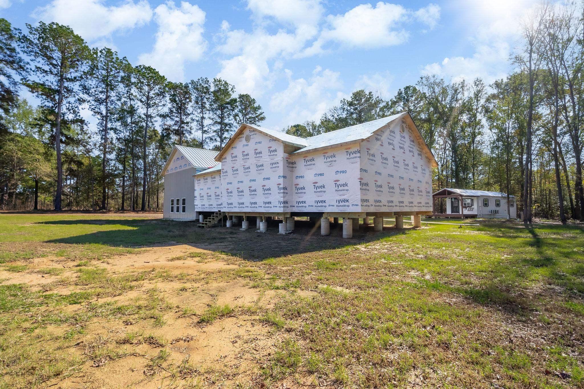 Image 1: View of property exterior with a yard and a deck, Side Of Structure