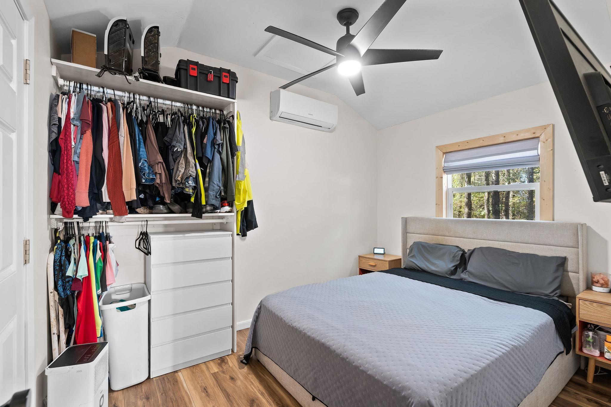 Image 2: Bedroom featuring a closet, wood finished floors, vaulted ceiling, a ceiling fan, and a wall mounted AC, Bedroom