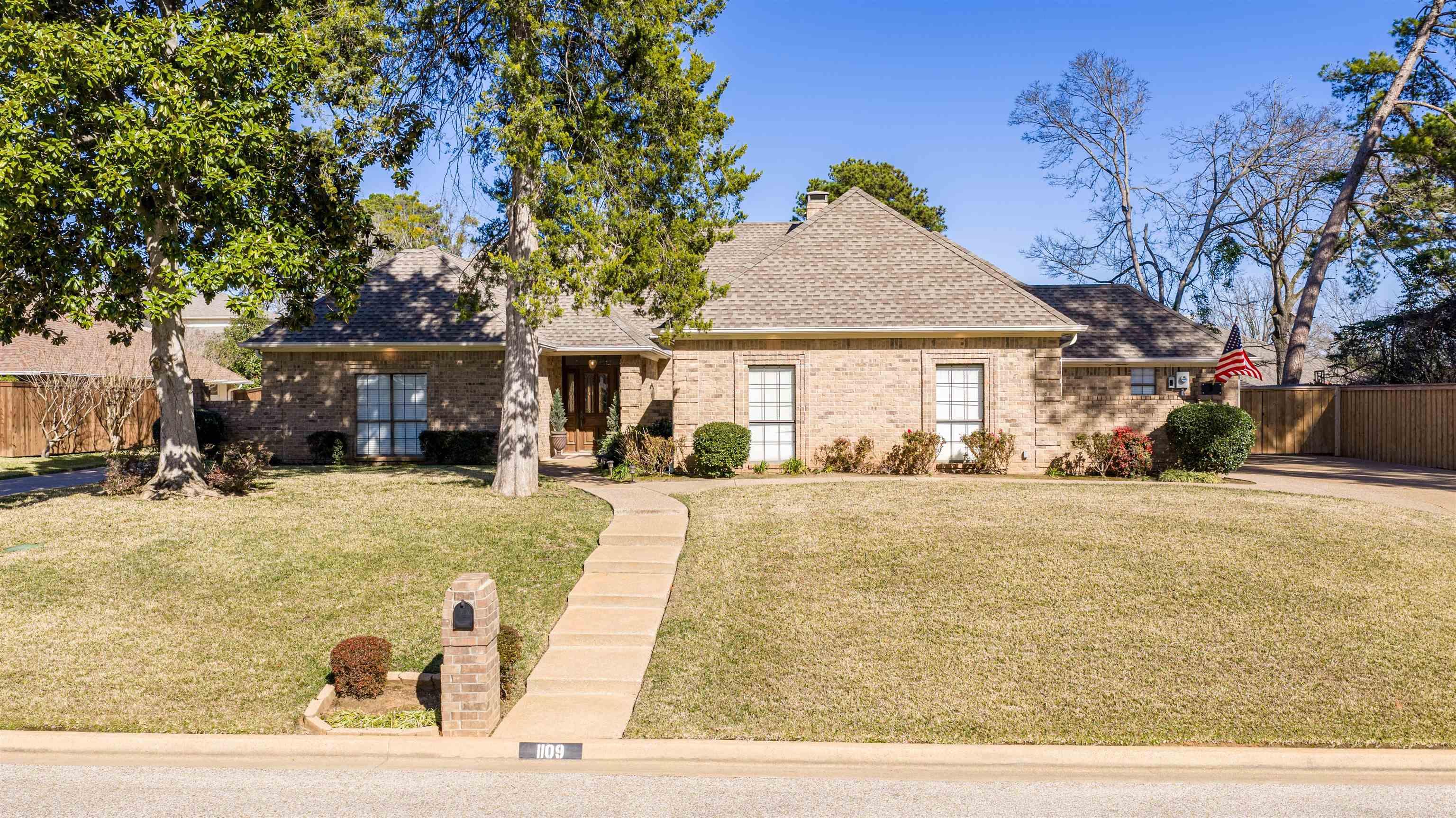 Image 0: View of front of home featuring brick siding and a shingled roof, Front Of Structure
