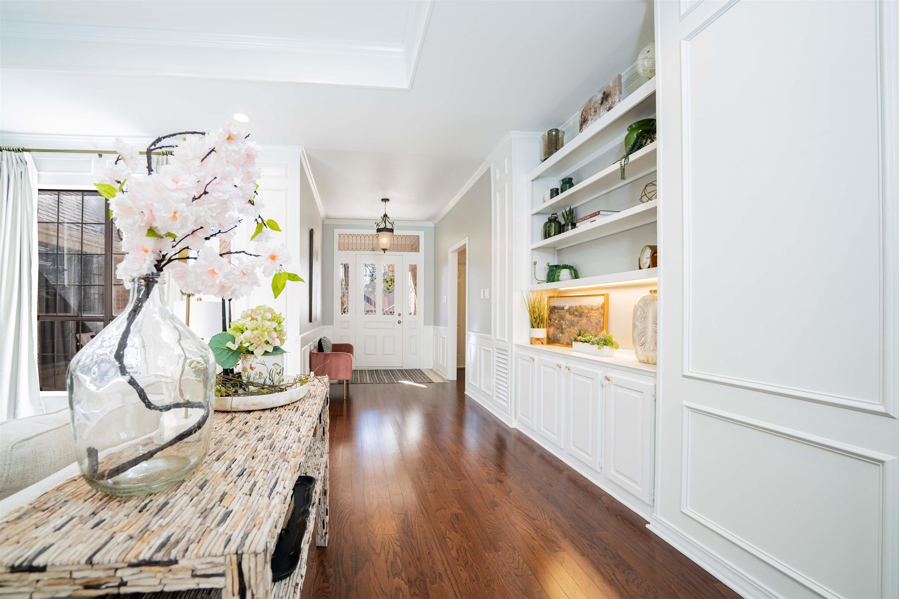 Image 2: Corridor featuring ornamental molding, dark wood finished floors, built in features, a decorative wall, and a wainscoted wall, Hallway