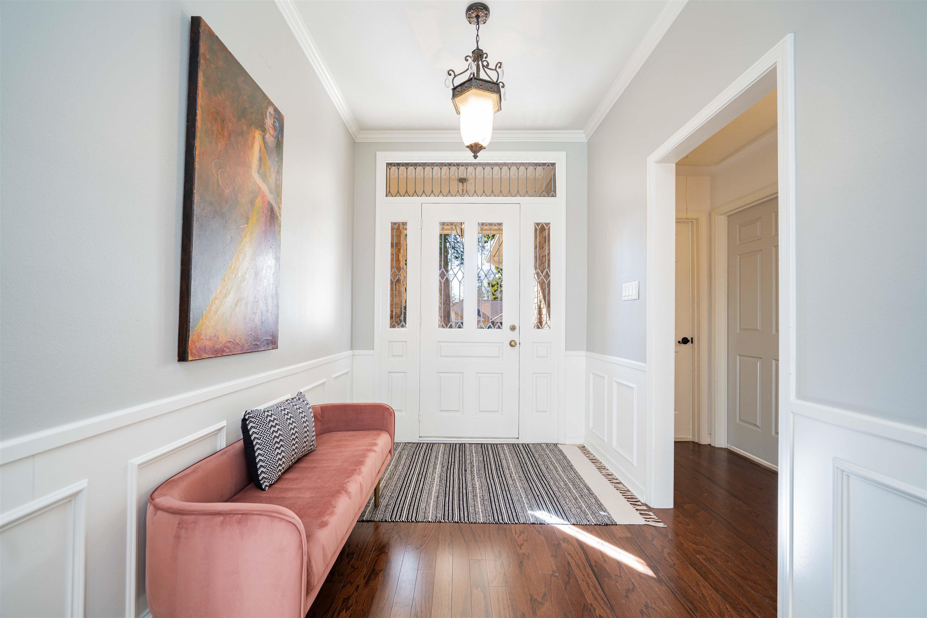 Image 3: Entryway with a wainscoted wall, wood-type flooring, crown molding, and a decorative wall, Entrance Foyer