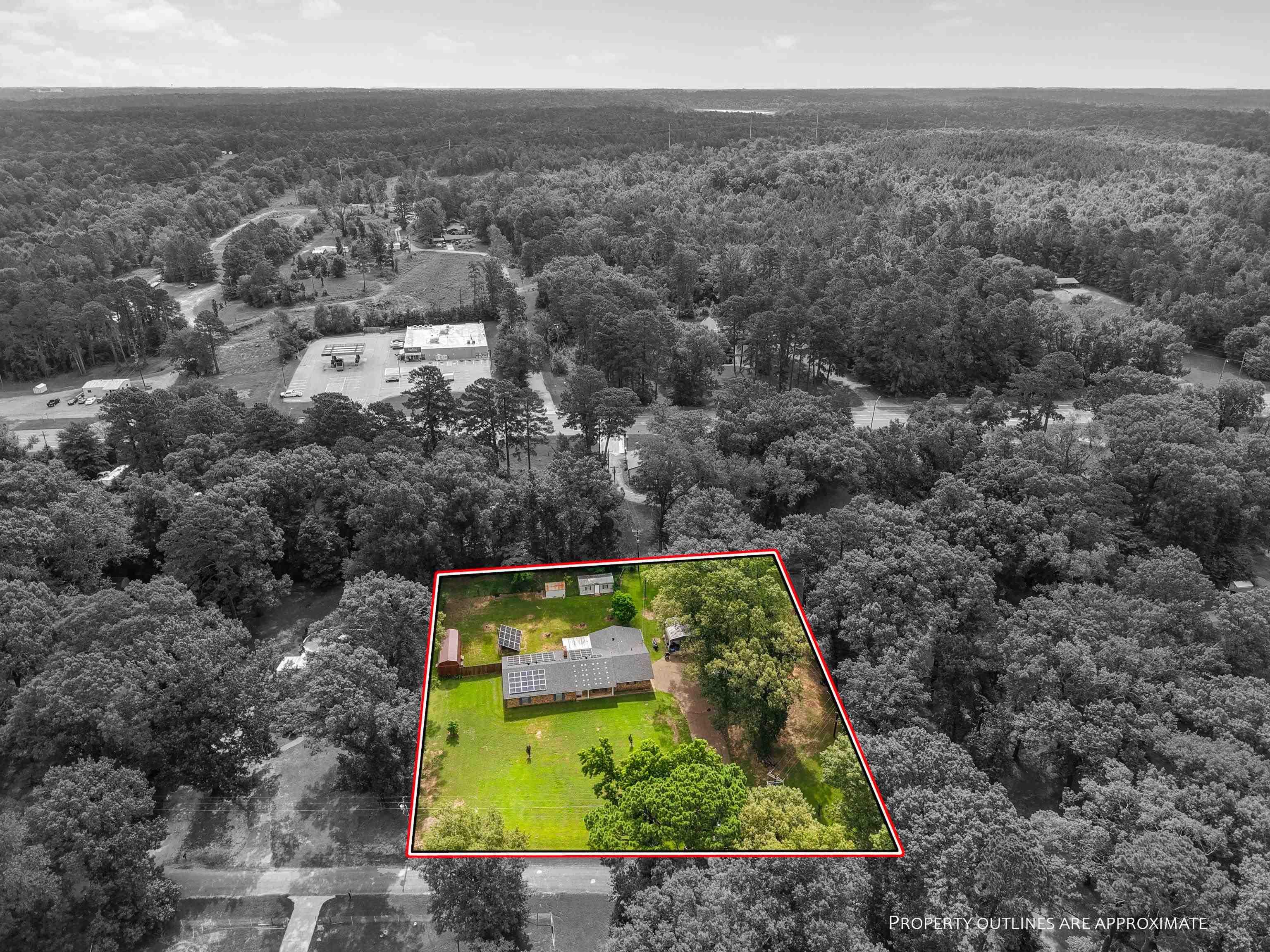 Image 2: Expansive property featuring a single-story residence, a verdant lawn, and mature trees, Aerial View