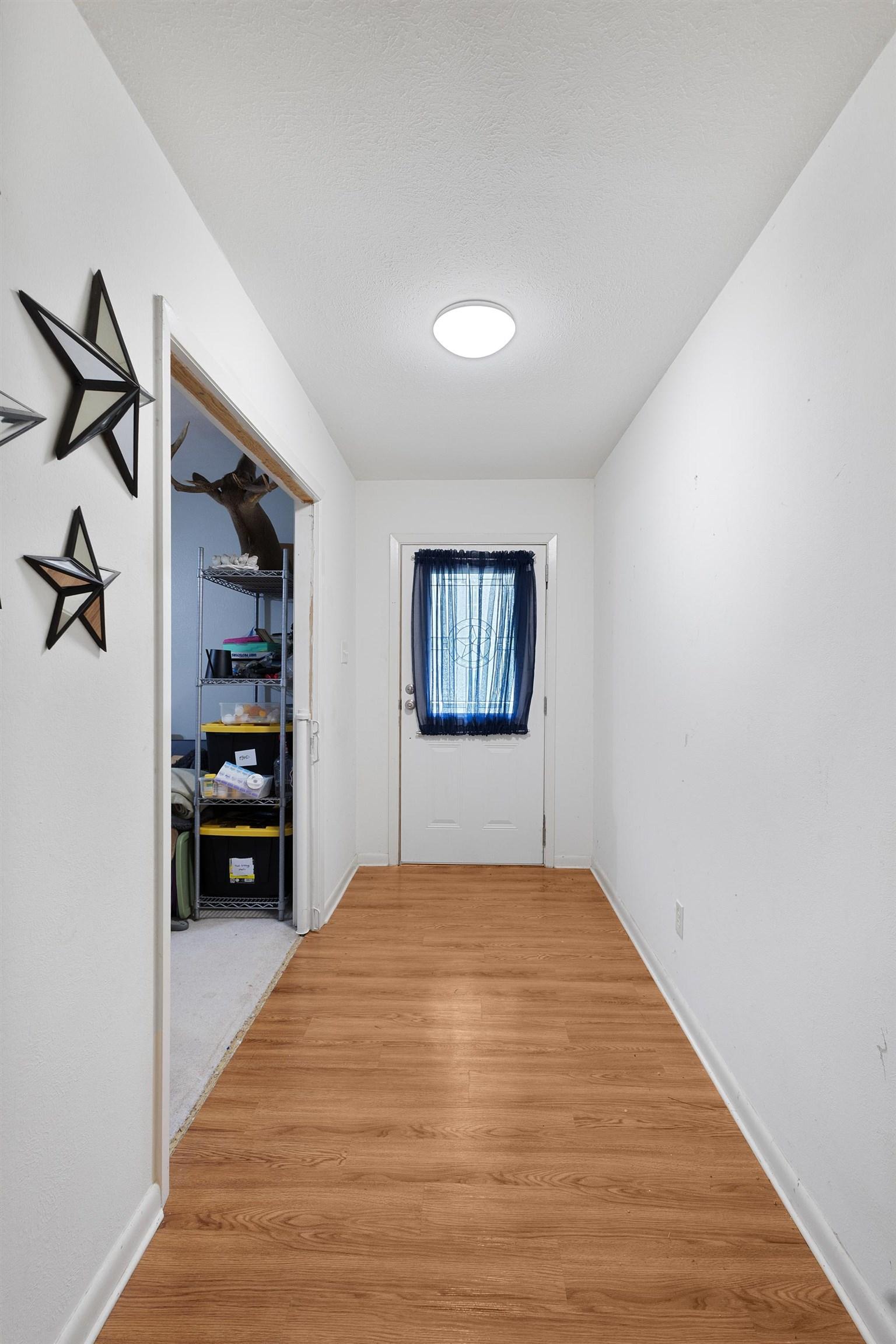 Image 3: Entryway featuring wood-finish flooring, white walls, and a flush-mount ceiling light, Hallway