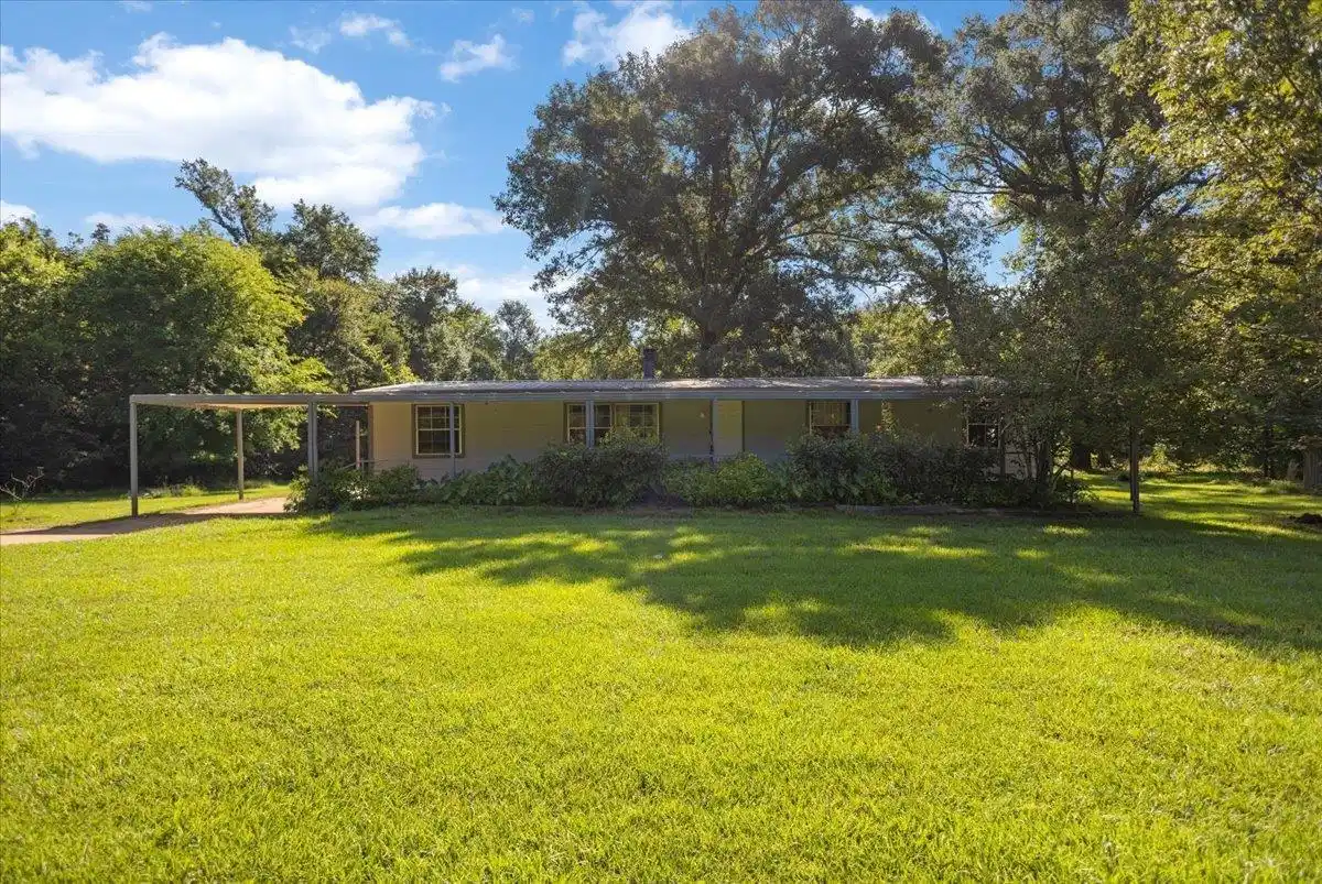 Image 0: Ranch-style residence featuring a covered front porch, carport, and a spacious front lawn, Front Of Structure