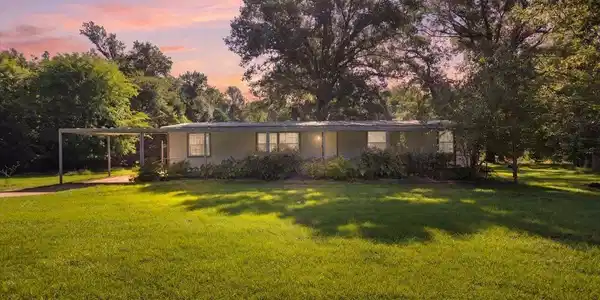 Image 2: Ranch-style residence featuring a carport and extensive front lawn, Front Of Structure