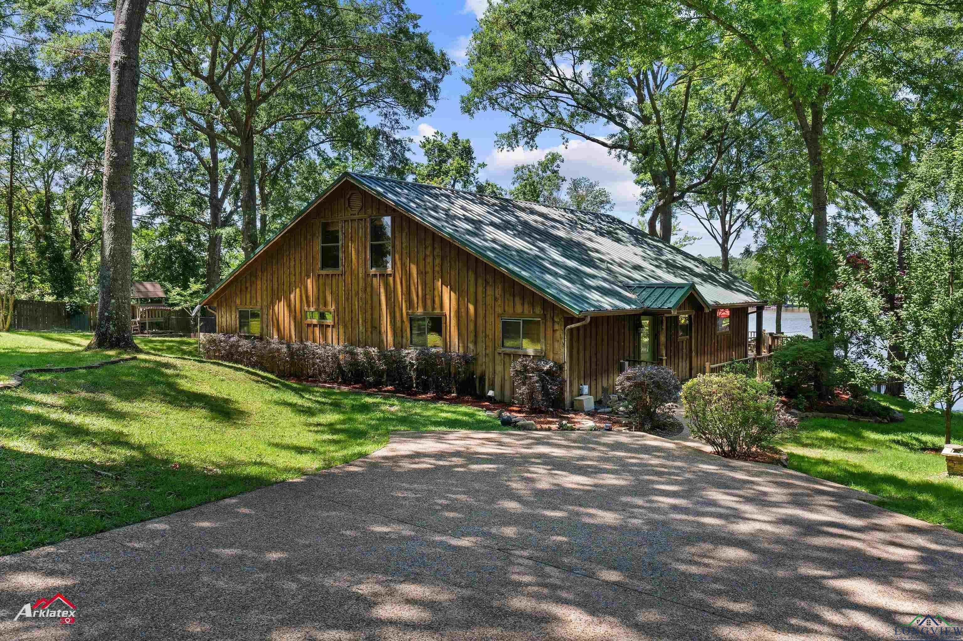 Image 3: Rustic home with a front yard, a standing seam roof, metal roof, and board and batten siding, Front Of Structure