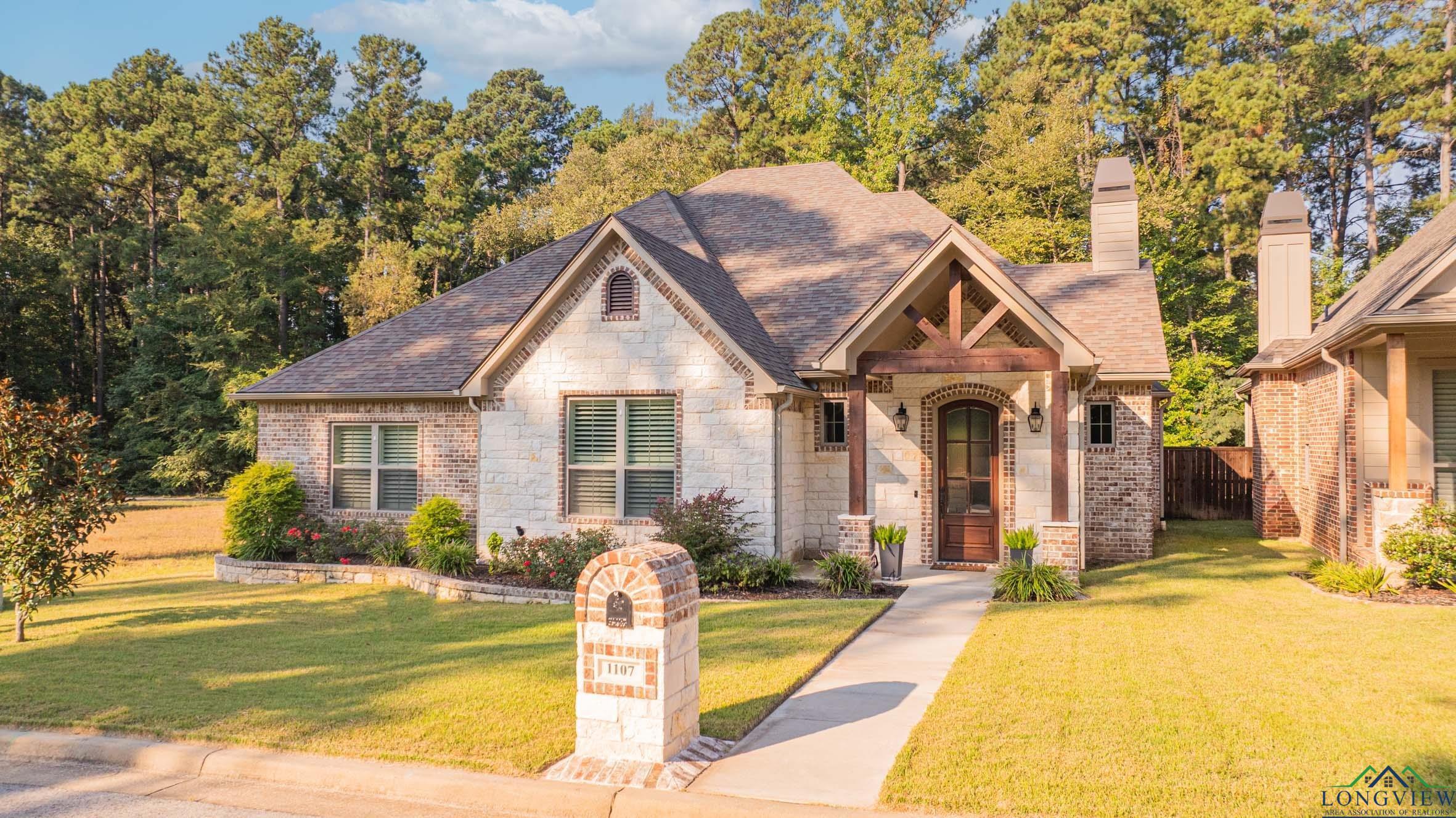 Image 1: View of front of home featuring a front lawn, a shingled roof, a chimney, and stone siding, Front Of Structure