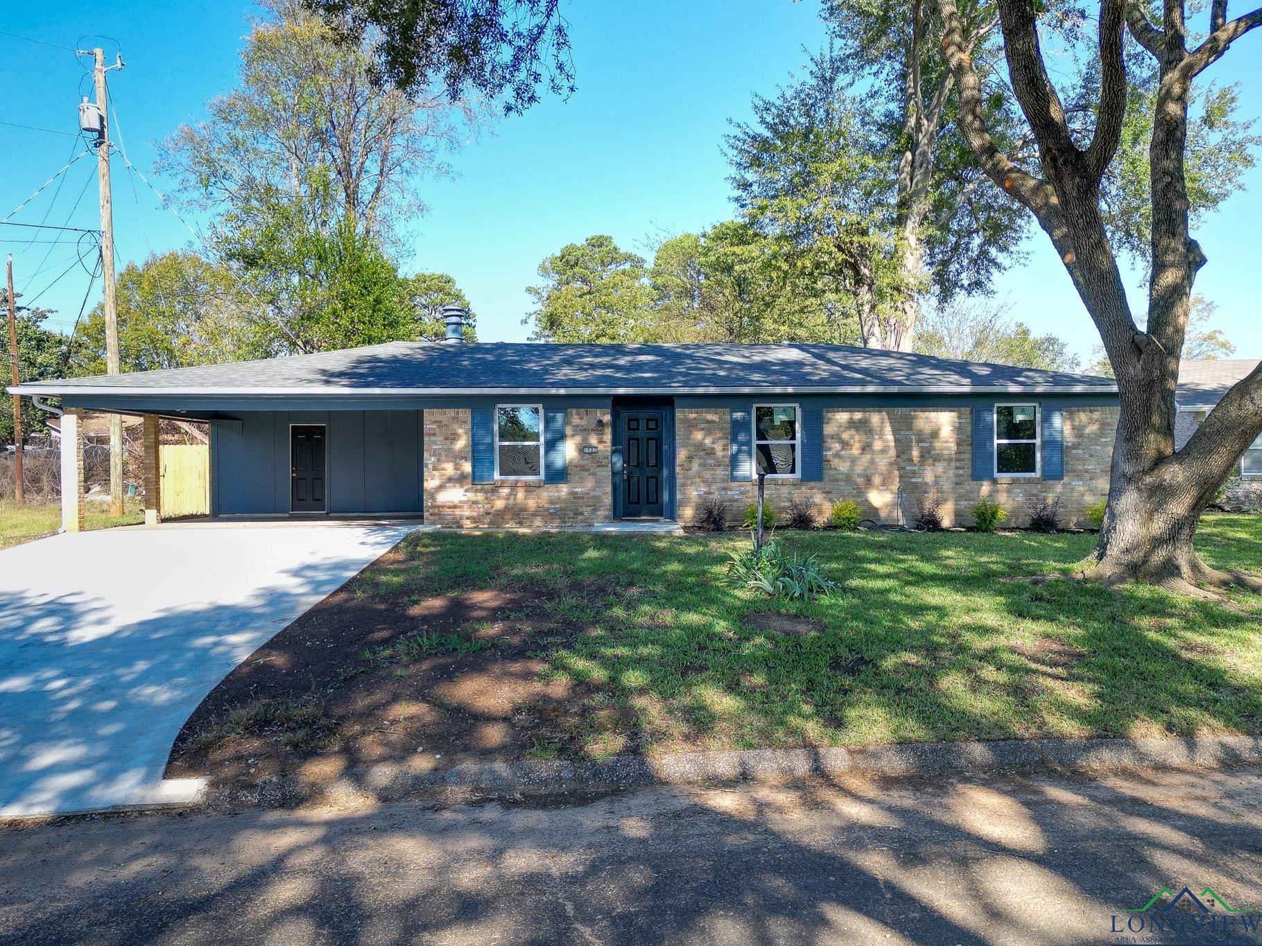 Image 0: Ranch-style home with a carport, driveway, and a front lawn, Front Of Structure
