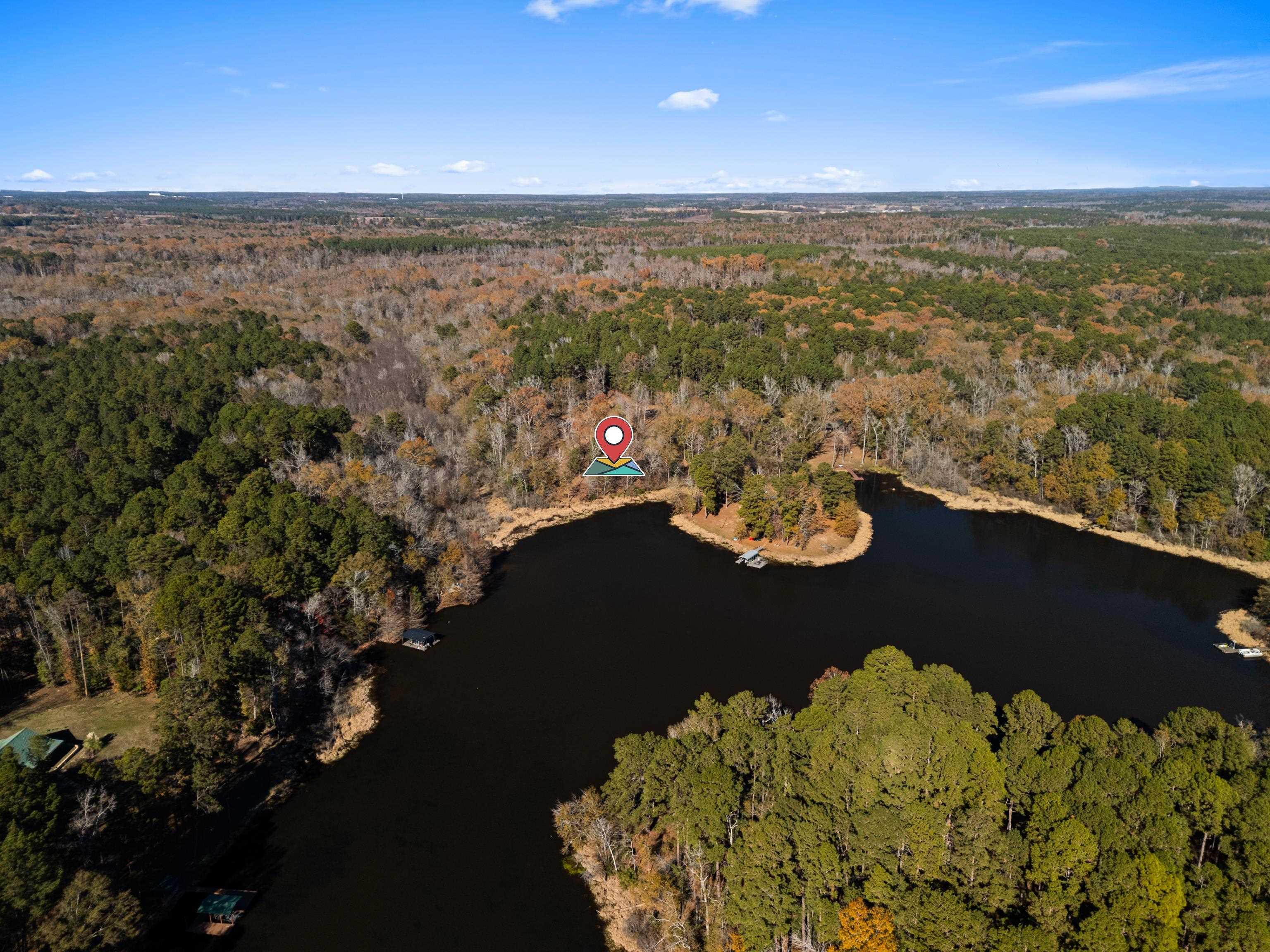 Image 1: Aerial view of property and surrounding area featuring a heavily wooded area, Aerial View