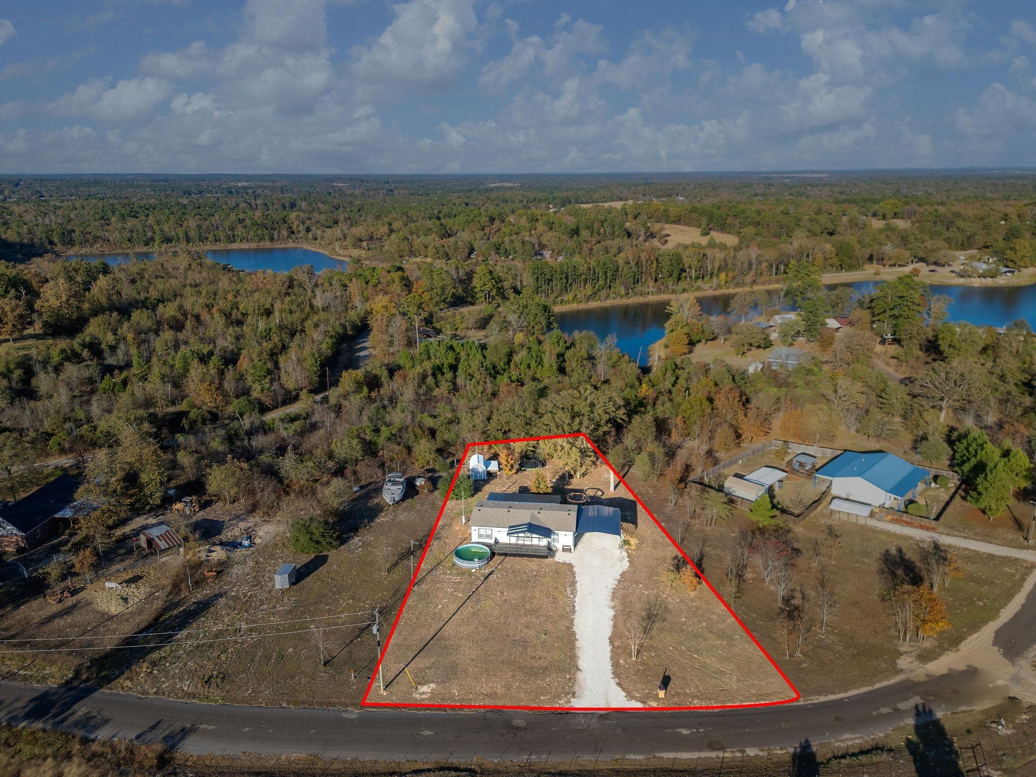 Image 1: Aerial overview of property's location featuring a nearby body of water and property parcel outlined, Aerial View