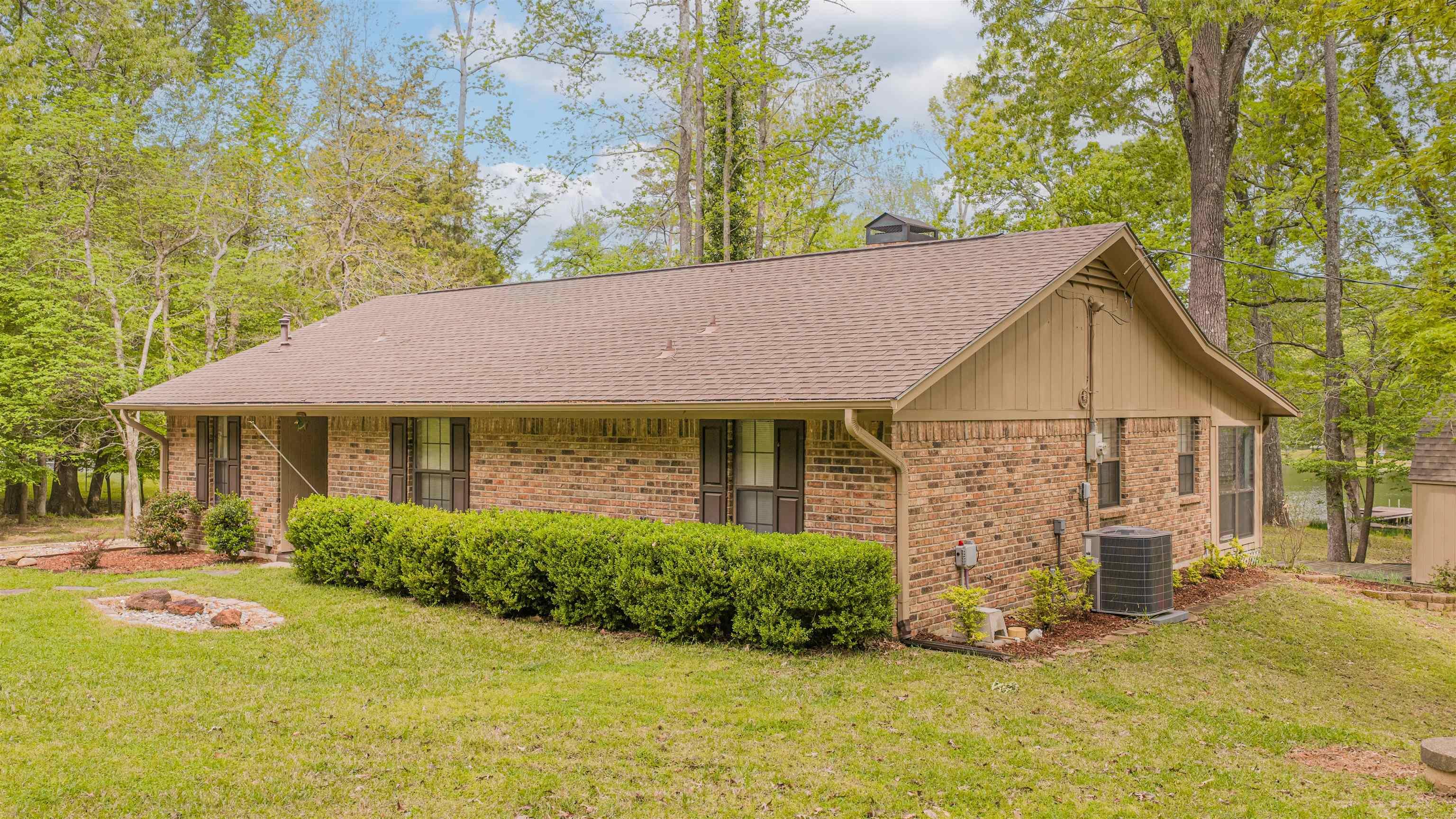 Image 3: View of front of home featuring a front yard, brick siding, and a shingled roof, Front Of Structure