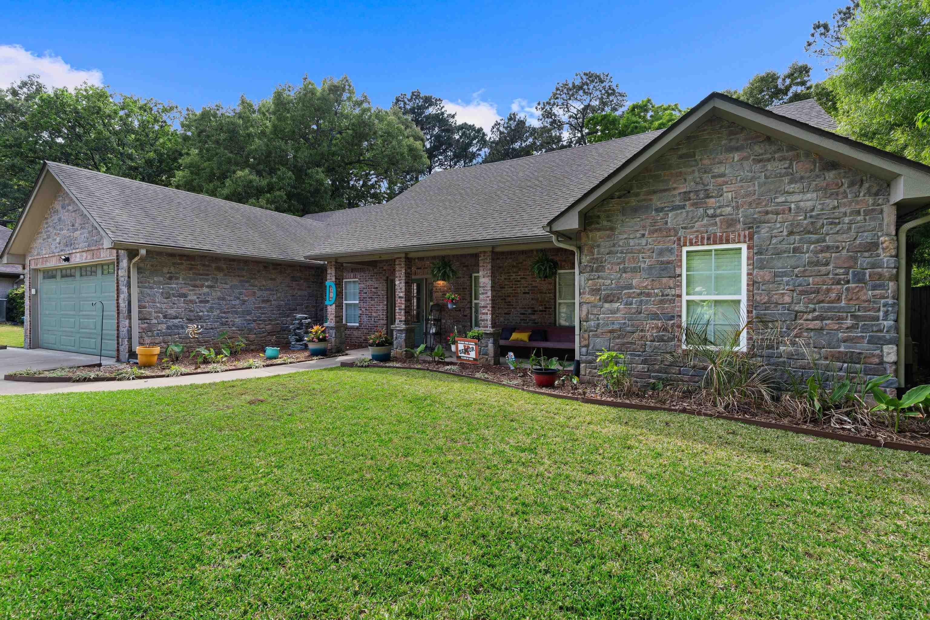 Image 1: Single story home featuring stone siding, a front lawn, and roof with shingles, Front Of Structure