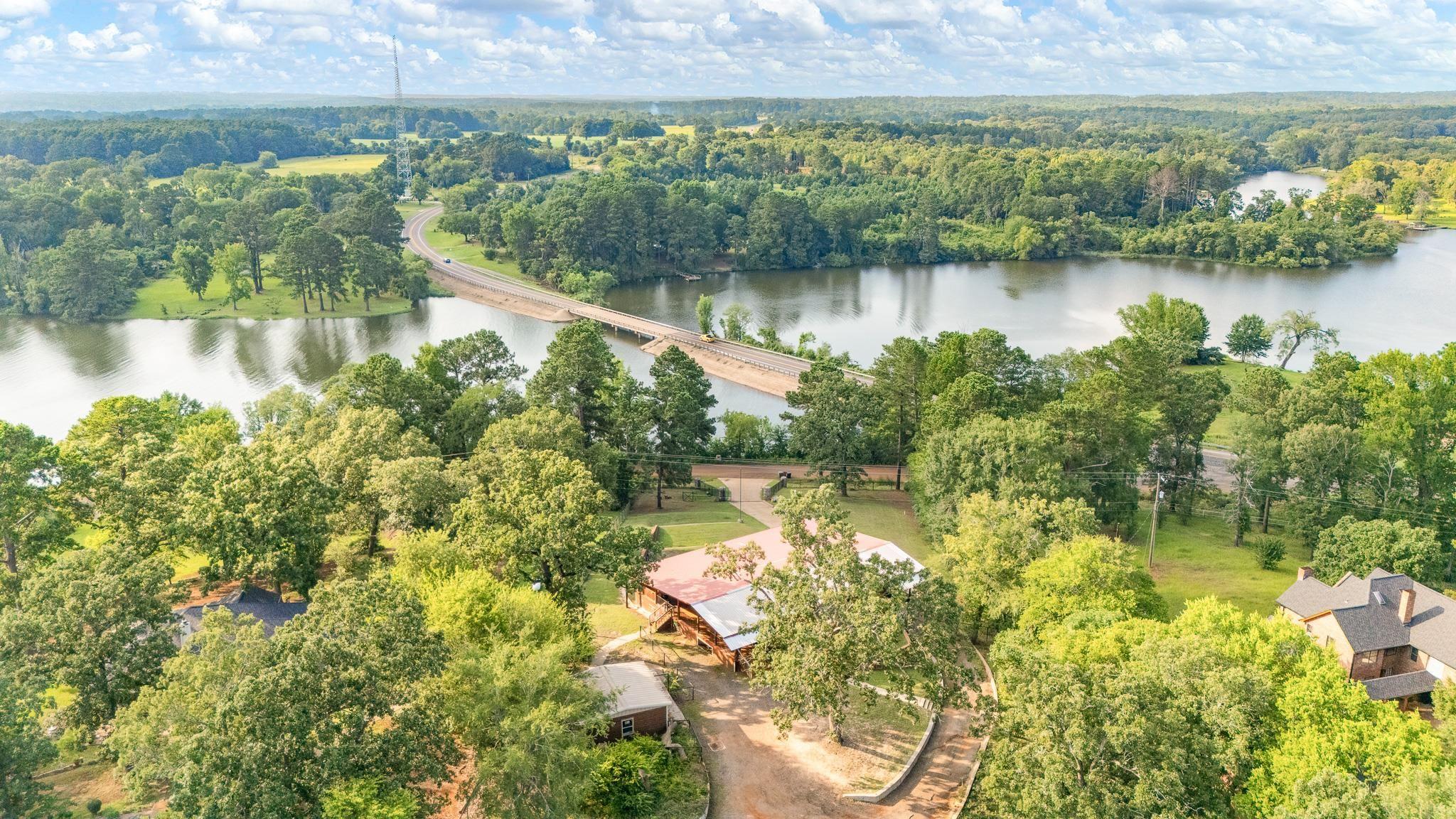 Image 2: Expansive property featuring a riverfront setting, mature tree coverage, a private drive, and multiple structures, Aerial View