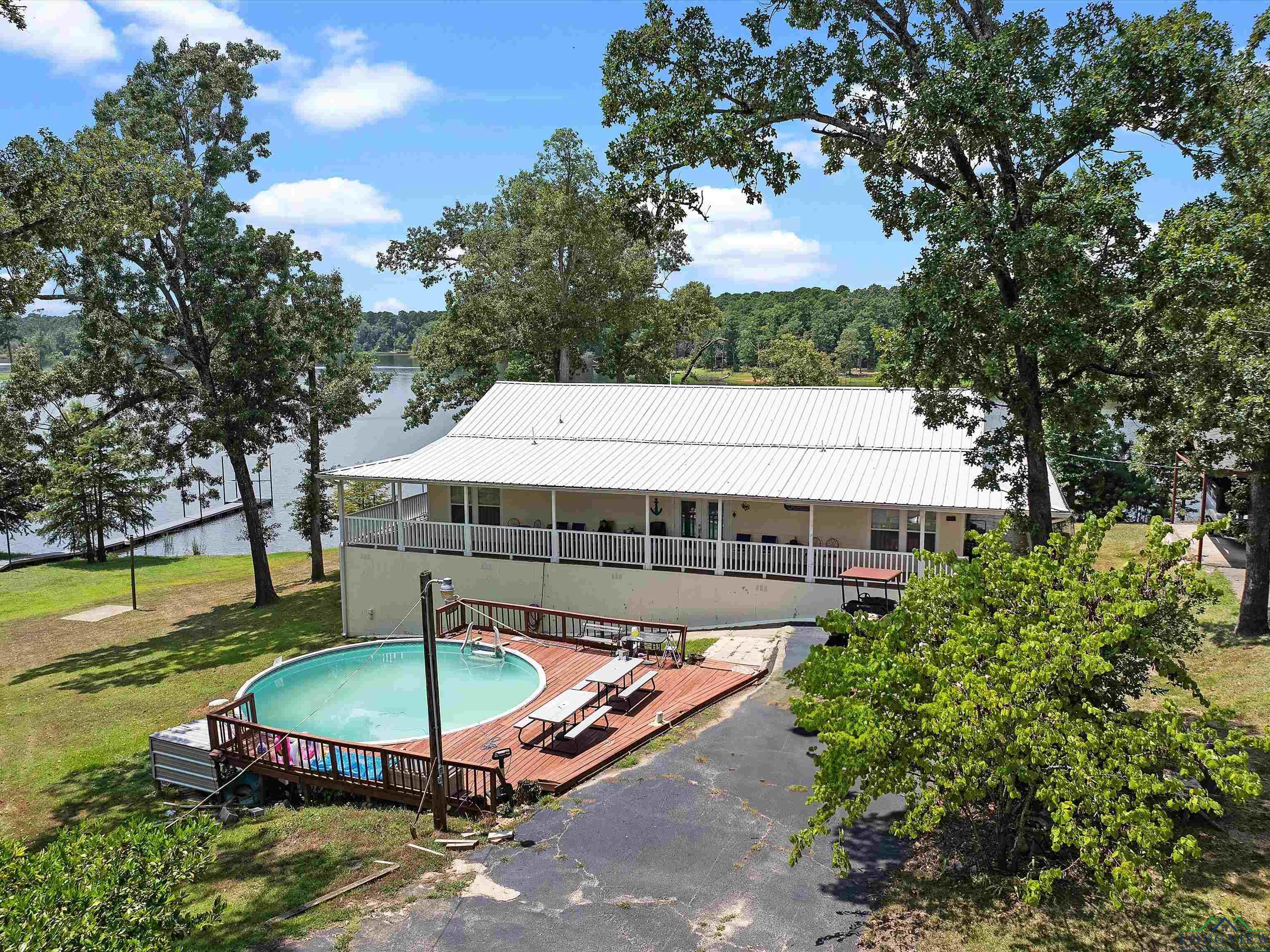 Image 2: Outdoor pool featuring a deck with water view and a yard, Pool