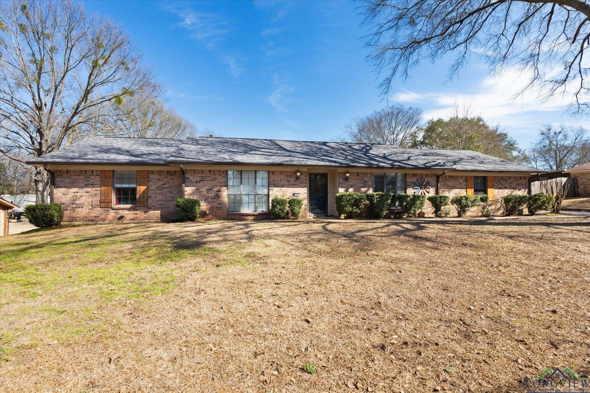 Image 1: Ranch-style home with brick siding and a front yard, Front Of Structure